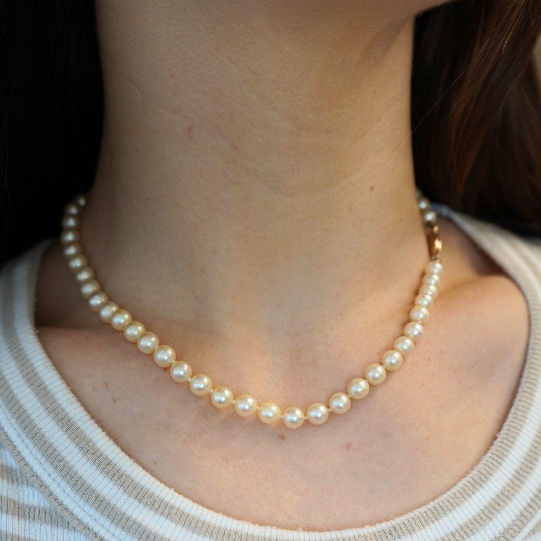 Ce collier de perles de culture est composé d'un rang de perles lustrées, chacune nouée individuellement pour plus de sécurité et d'élégance. Le collier mesure 16 pouces de long et 1/4 de pouce de large, pour un poids total de 20,8 grammes. Il est