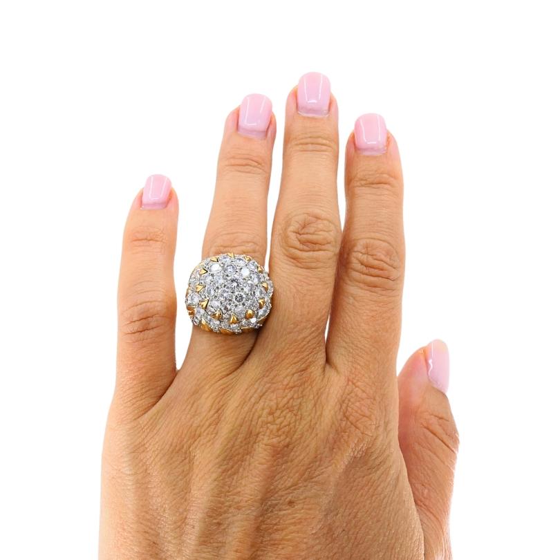 Cette bague de cocktail vintage audacieuse et glamour se distingue par son design sophistiqué et son éclat éblouissant. Réalisée en or jaune 14k, la bague présente une forme de dôme spectaculaire richement pavée de diamants. Les pierres sont