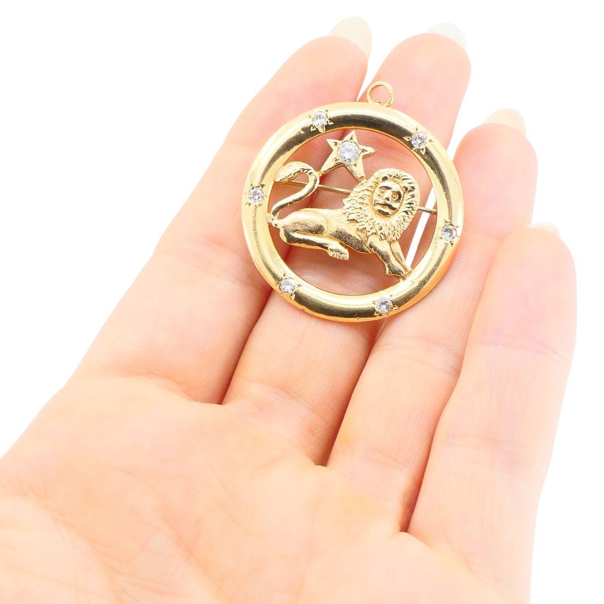 Questo pezzo di metà secolo presenta un leone finemente modellato che riposa all'interno di una cornice circolare ornata da sette diamanti rotondi, ciascuno incastonato in un motivo a stella. Una stella più grande si erge sopra la schiena del leone,