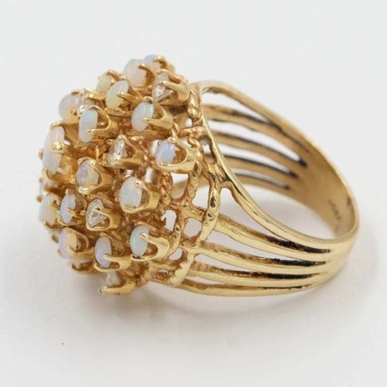 Gorgeous vintage ring. It is made out of 14K gold that holds many little beautiful opal and clear stones. Opals have a nice range of color including white, yellow, green, and blue so that this ring will go with everything.