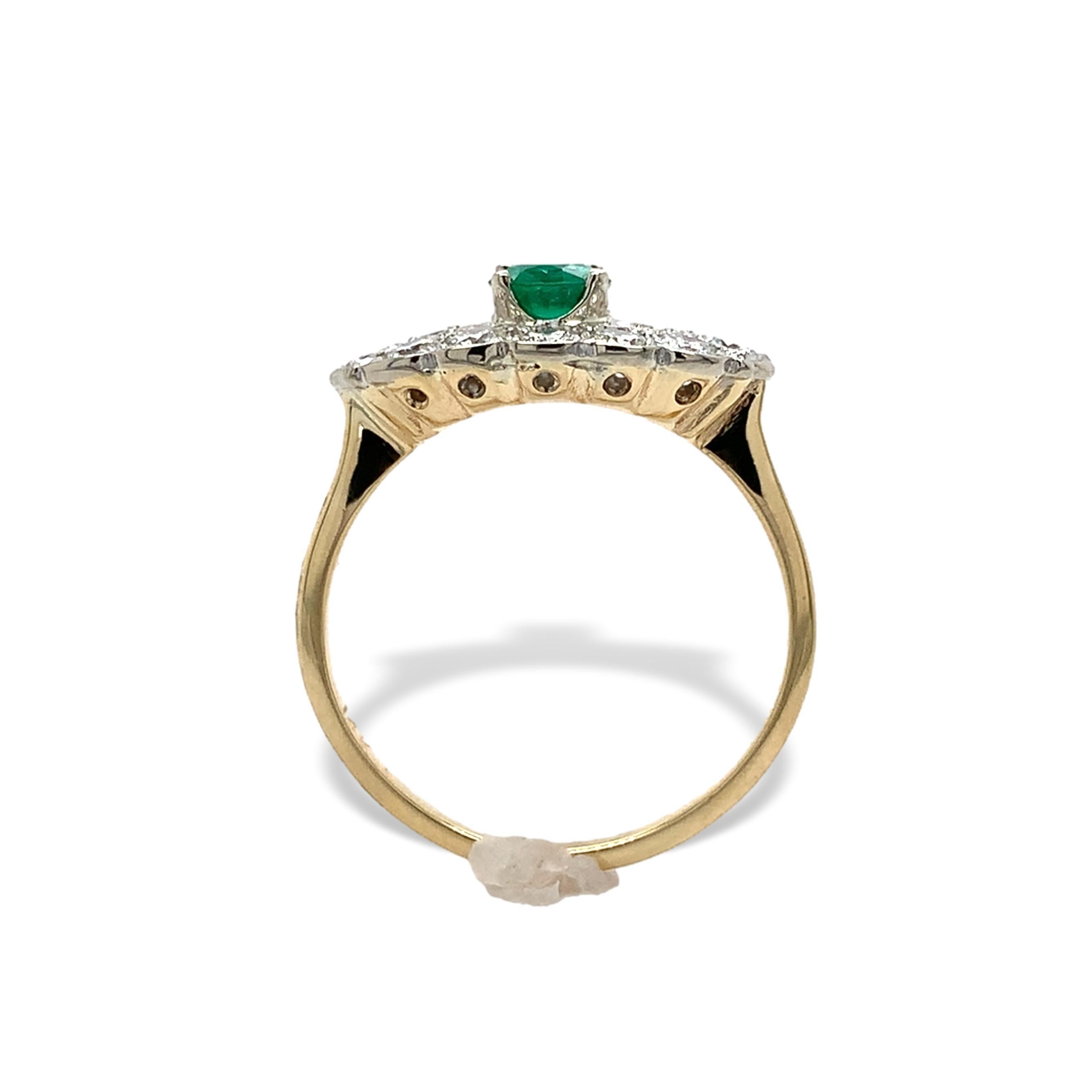 Anello in oro giallo 14K con smeraldo e 14 diamanti rotondi incastonati in oro bianco. Lo smeraldo rotondo è di un brillante colore verde erba e pesa 0,35 carati. Lo smeraldo misura circa 4,7 mm. Ci sono 12 diamanti rotondi taglio brillante di circa