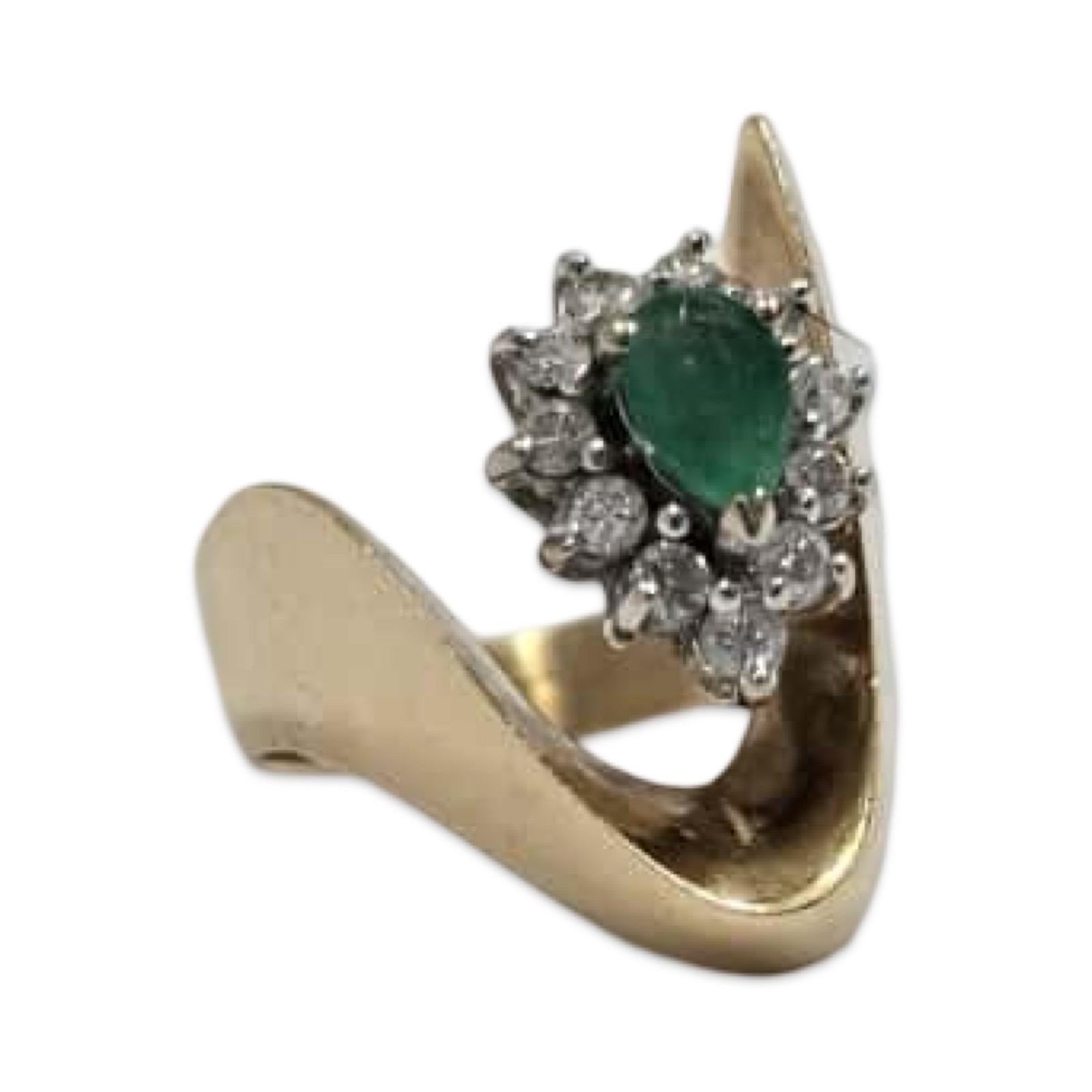 Élégante bague by-pass en or jaune 14 carats pesant 5,8 grammes, ornée d'une émeraude en forme de poire mesurant 4 mm × 6 mm (environ 0,40 ct) entourée de 11 diamants ronds de taille brillant, chacun d'environ 2,25 mm (environ 0,44 ct au total). Le