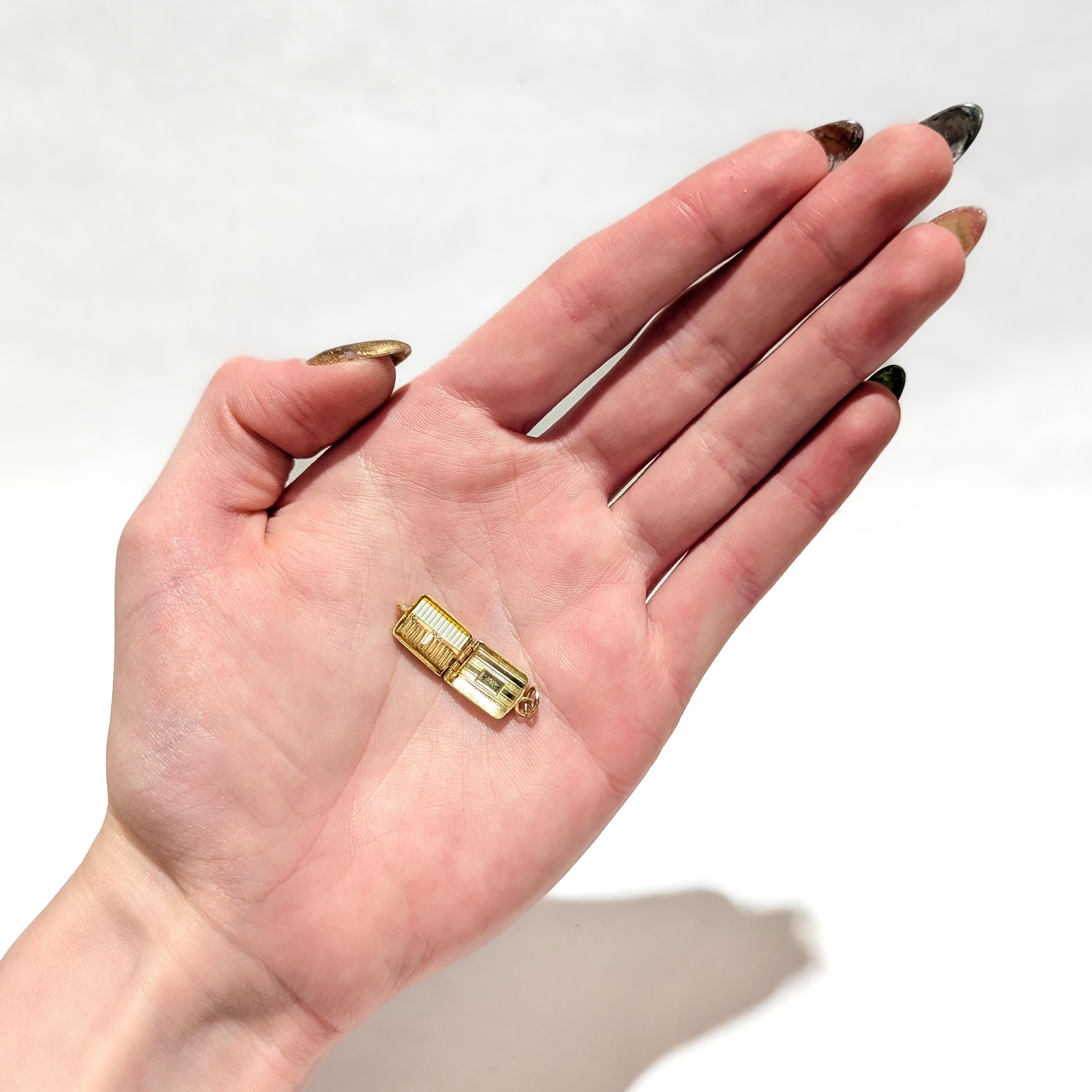 Un raffinato charm vintage in oro e smalto per un braccialetto di charme.

In oro giallo 14 carati.

A forma di portasigarette trasformato in motore con sigarette smaltate all'interno.

Con una cauzione integrale e un anello per saltare.

Un fascino