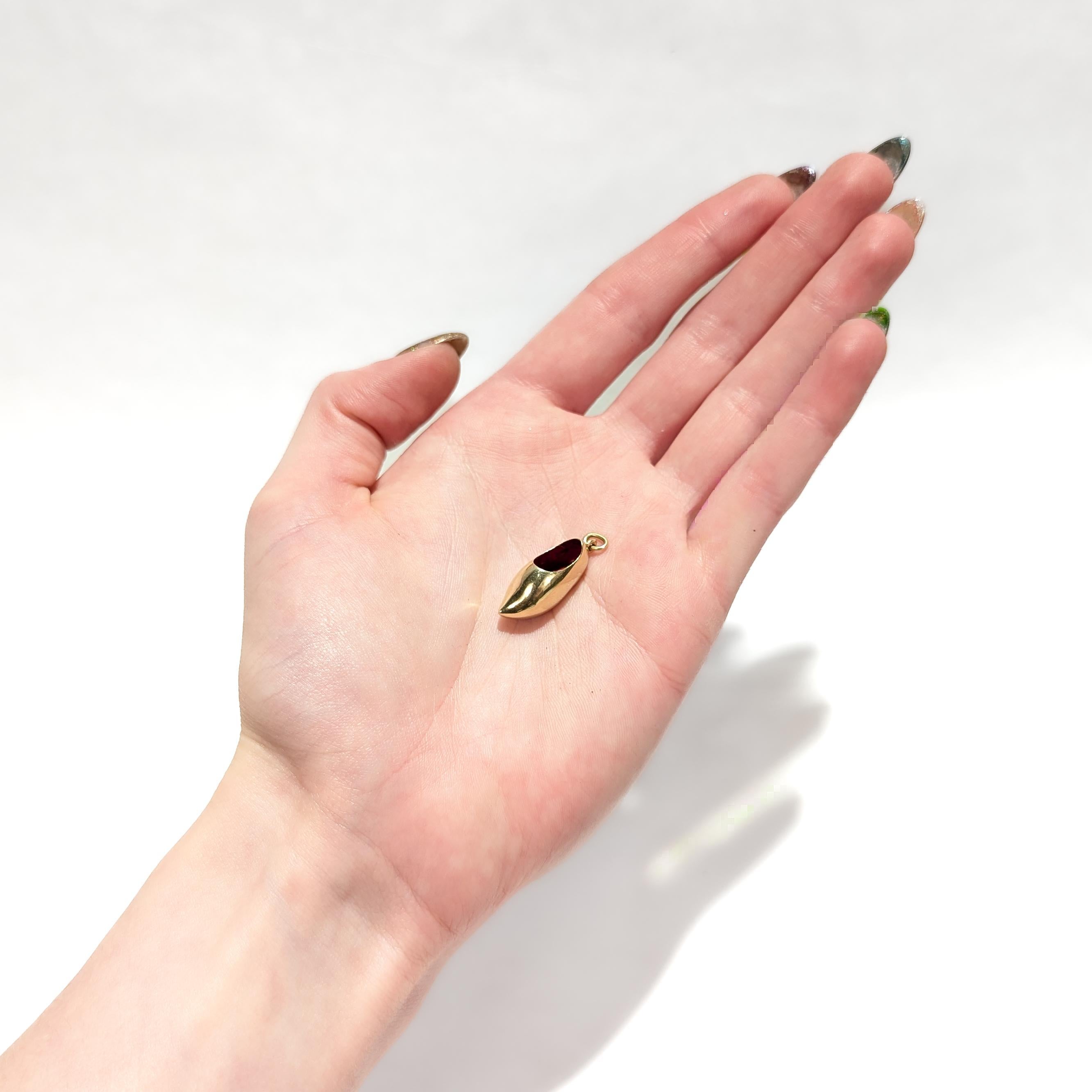 A fine vintage figural gold charm.

In 14 karat yellow gold.

In the form of a wooden clog (like the traditional Dutch klompen) with red enamel accent to the interior.

With an integral bail and jump ring to the heel.

Simply a wonderful