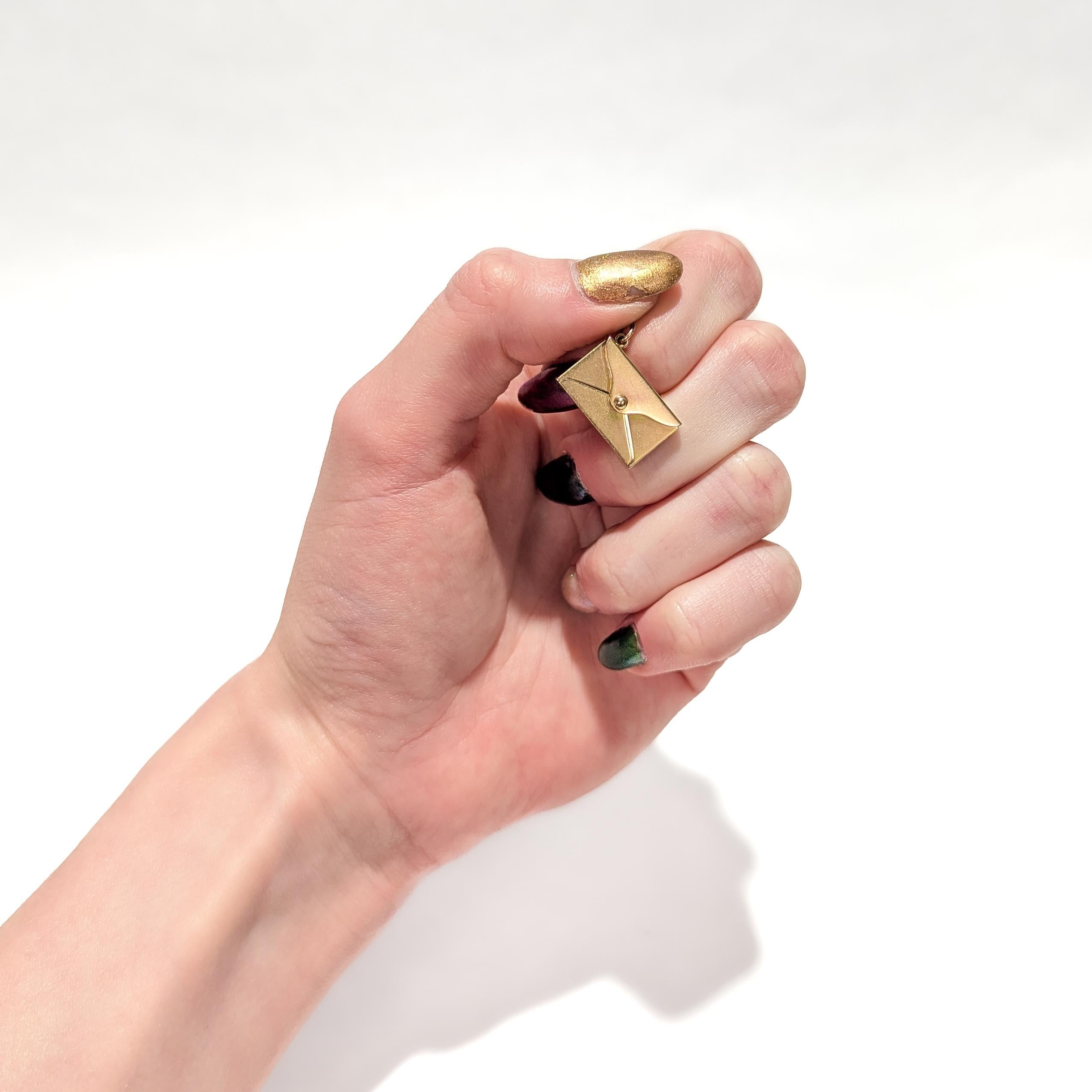 A fine vintage gold charm for a charm bracelet.

In 14 karat yellow gold.

In the form of a envelope. 

The closing flap is hinged and can be opened and close. There is space inside the envelope to insert a small message.

Simply a wonderful