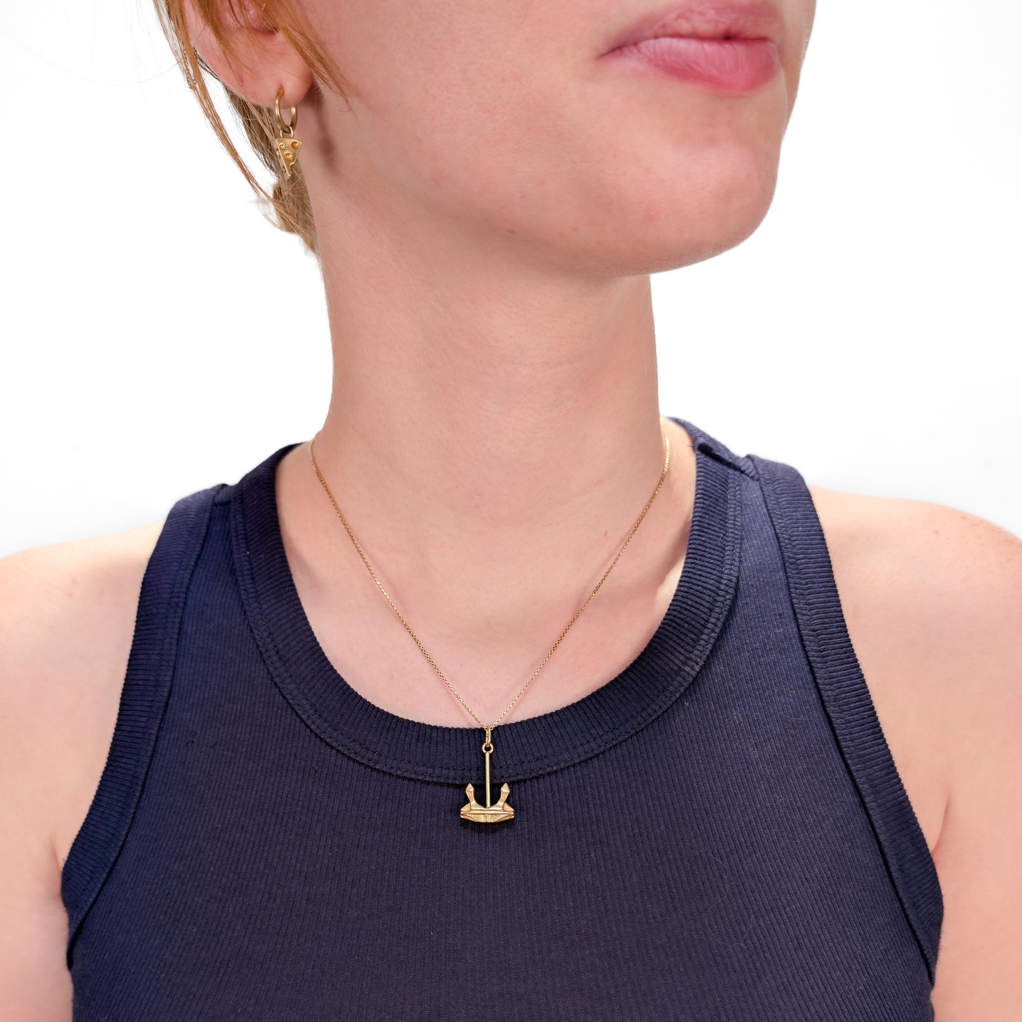 Un raffinato ciondolo d'oro figurato d'epoca.

In oro giallo 14 carati.

Sotto forma di un'ancora industriale. 

Con un anello di sospensione alla parte superiore dell'ancora.

Marcato sull'anello di sospensione.

Un fascino semplicemente