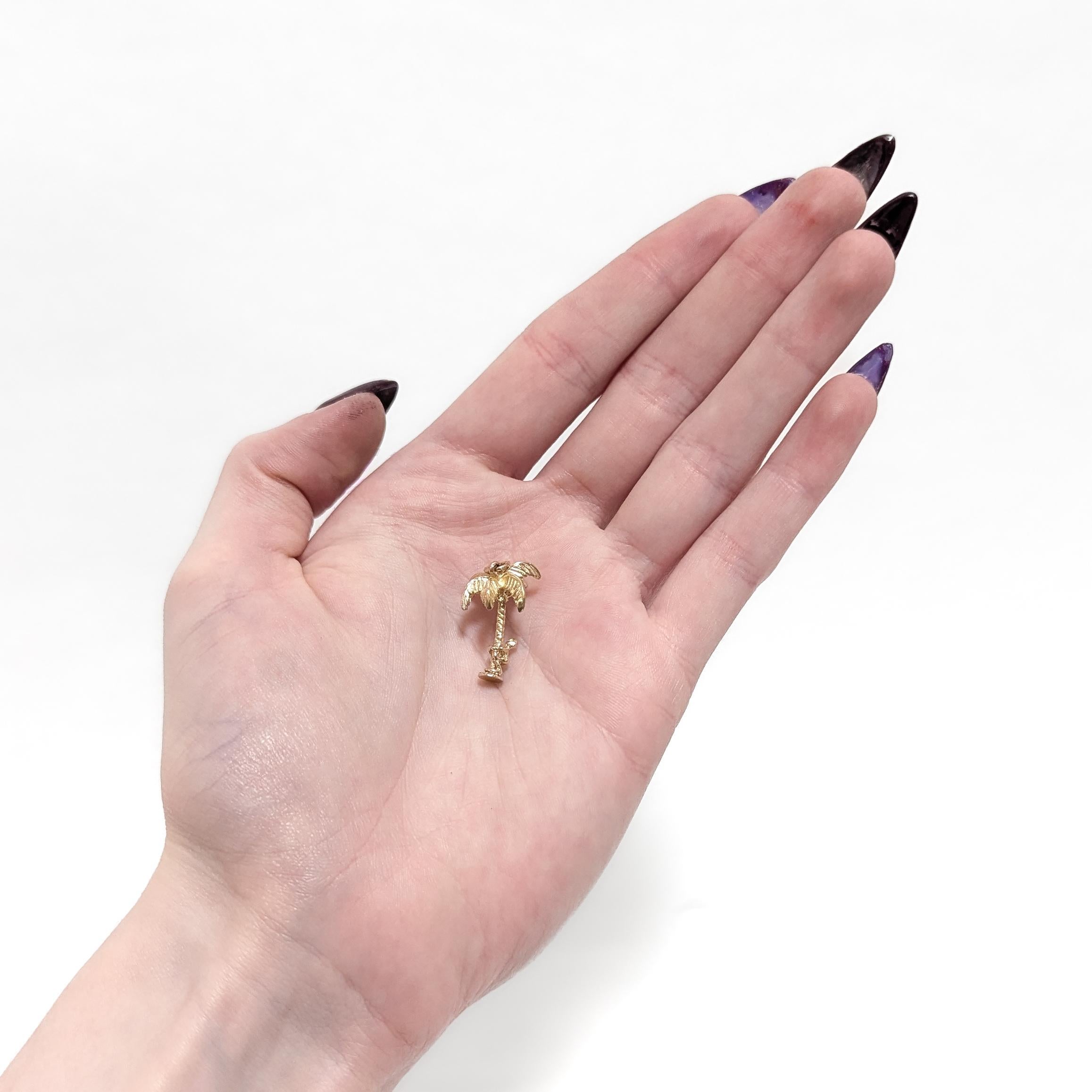 Une breloque en or vintage pour un bracelet.

En or jaune 14 carats.

Sous la forme d'un palmier avec un homme grimpant qui peut être déplacé le long du tronc.

Le sommet de l'arbre est muni d'un anneau de sécurité et d'un anneau de saut.

Un charme