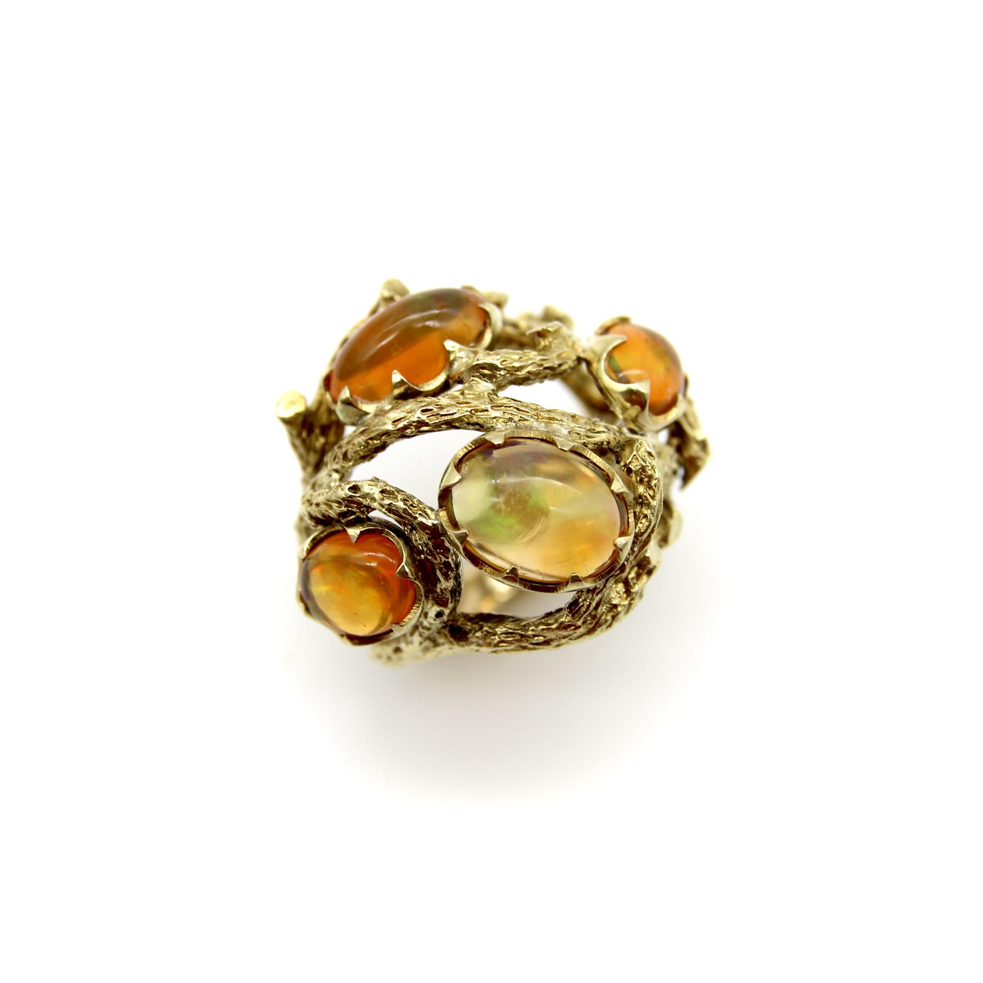 This 14k gold ring is reminiscent of a briar patch, with four iridescent fire opals held within twisted vines of 14k gold. The gorgeous fire opals are mesmerizing to look at—they have beautiful orange overtones with flashes of green and purple that