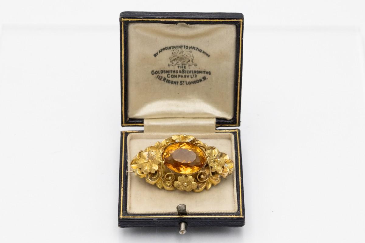 An old brooch made of 14-karat yellow gold with an openwork form and a floral motif. 

Its central point is an oval, faceted citrine with a deep yellow-orange color and a mass of approx. 9.60 ct.

Dimensions: 4 x 2 cm.

Weight: 5.86 g.

Origin: