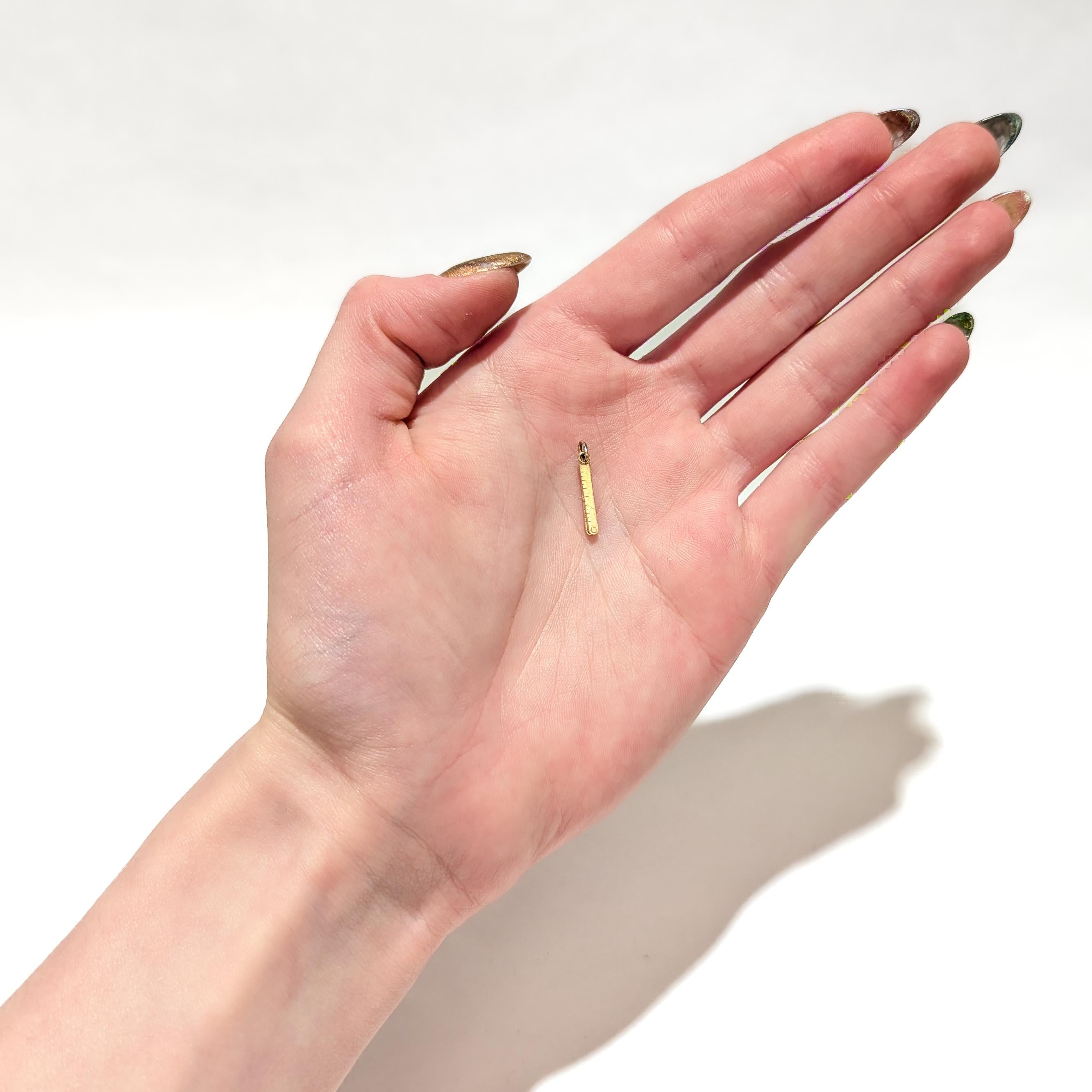 Un raffinato charm in oro vintage per un braccialetto di charme.

In oro giallo 14 carati.

A forma di righello pieghevole o di bastone di misurazione con 4 sezioni. 

Con un anello di sicurezza e un anello di salto integrato a un'estremità del