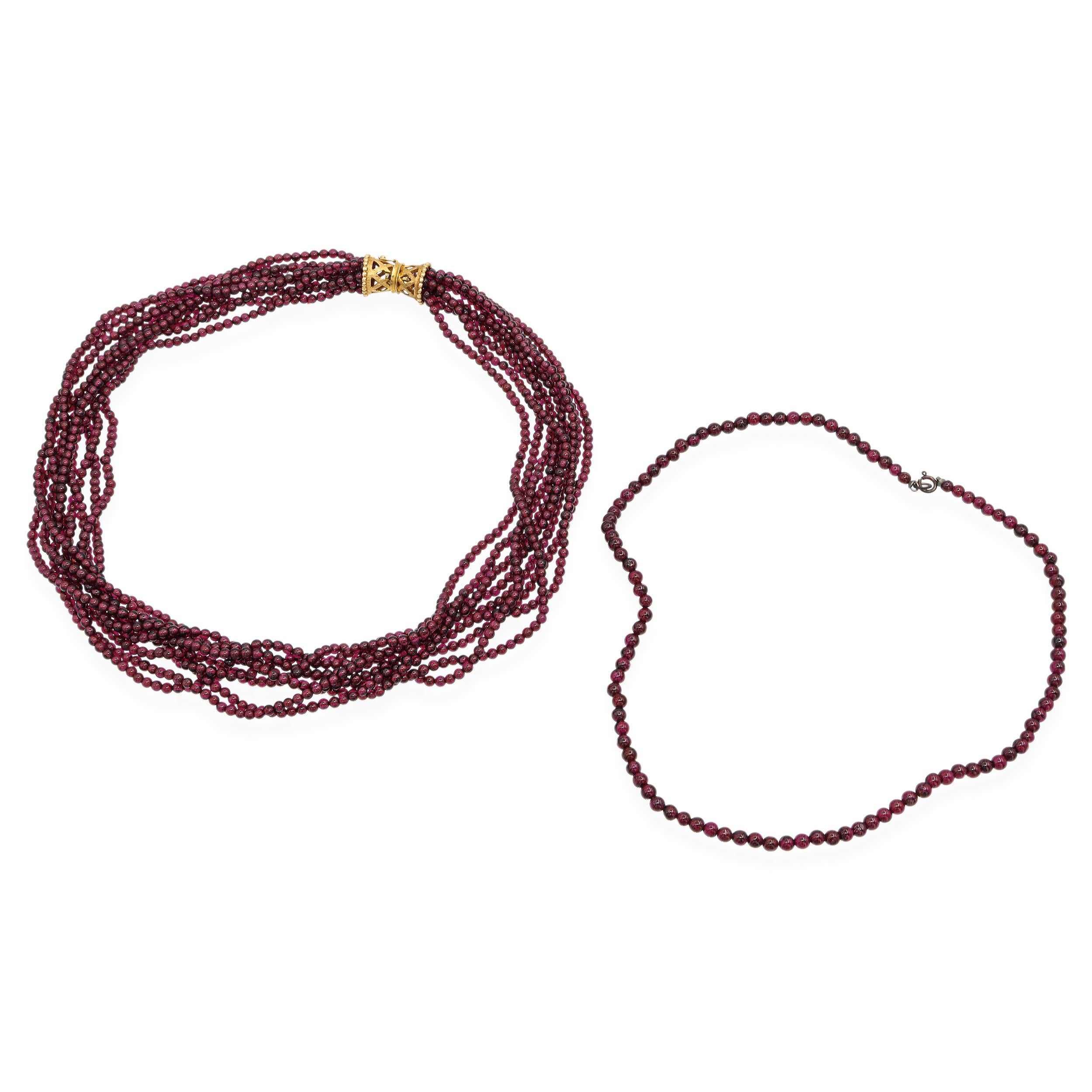 Elegant collier vintage composé de perles de grenat d'un rouge profond et de riches accents en or jaune 14K. L'ensemble comprend un collier spectaculaire à plusieurs brins de grenat avec un fermoir en or 14 carats, et un collier complémentaire à un