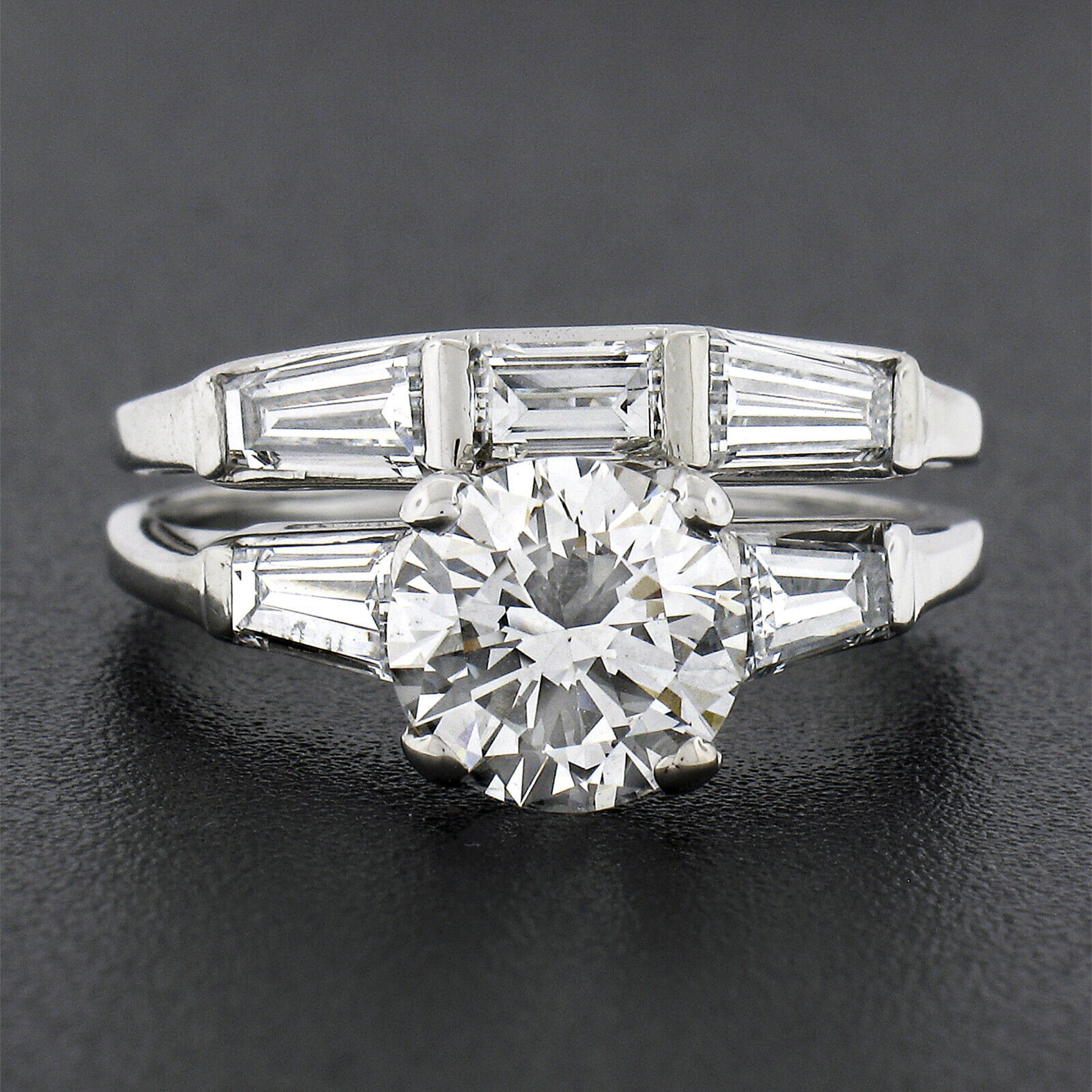 This absolutely magnificent vintage diamond engagement ring and wedding band set was crafted from solid 14k white gold. The engagement ring features a stunning, GIA certified, round brilliant diamond solitaire neatly prong set at the center with two