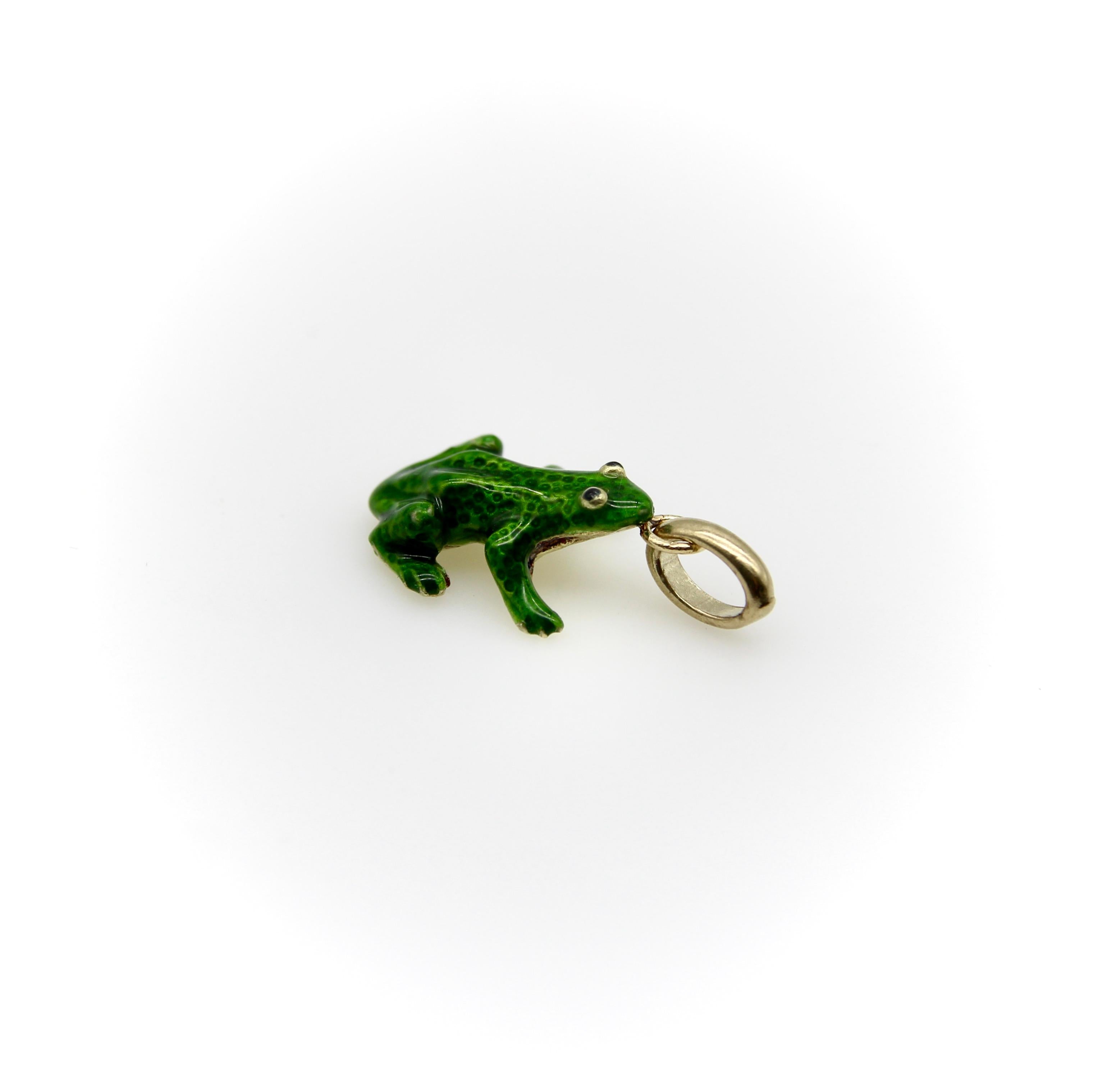 This 14k gold frog charm is detailed and lifelike, posed as if he were about to leap into the air. The charm is covered in green guilloche enamel, transparent enough to reveal the textured gold underneath it. The enamel settles nicely into the