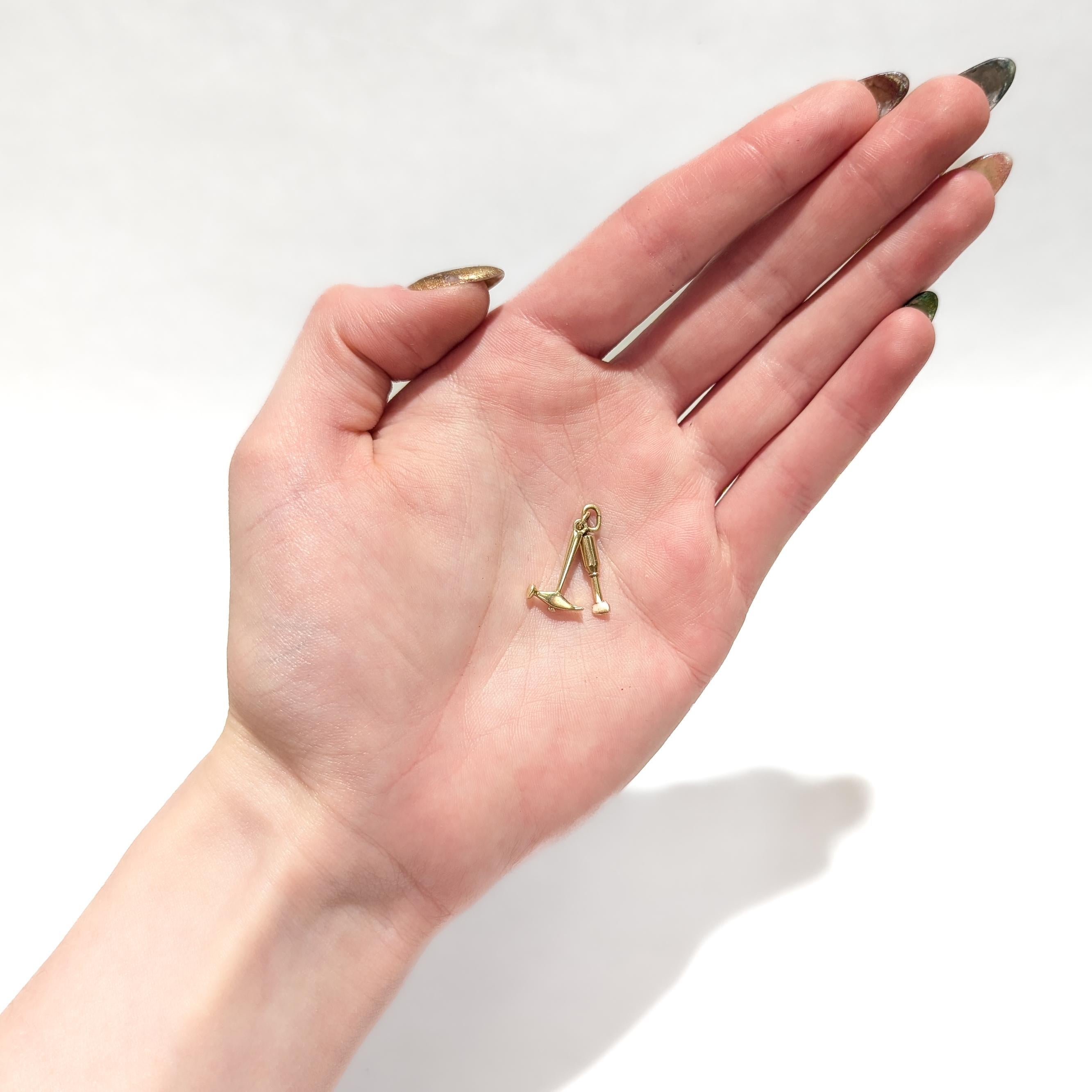 Un raffinato charm in oro vintage per un braccialetto.

In oro giallo 14 carati.

A forma di martello e scalpello.

Entrambi i martelli e gli scalpelli sono dotati di chiodi integrali e sono collegati a 2 anelli.

Un fascino semplicemente