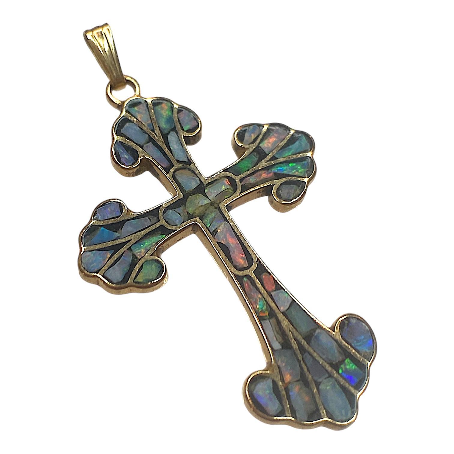 14K yellow gold cross pendant, featuring mixed-cut opal inlays with a vibrant multi color fire. The opals are set within a gold framework, creating a striking mosaic effect.
Bright polish finish enhances the intricate design.
Measurements: 38.0 mm H