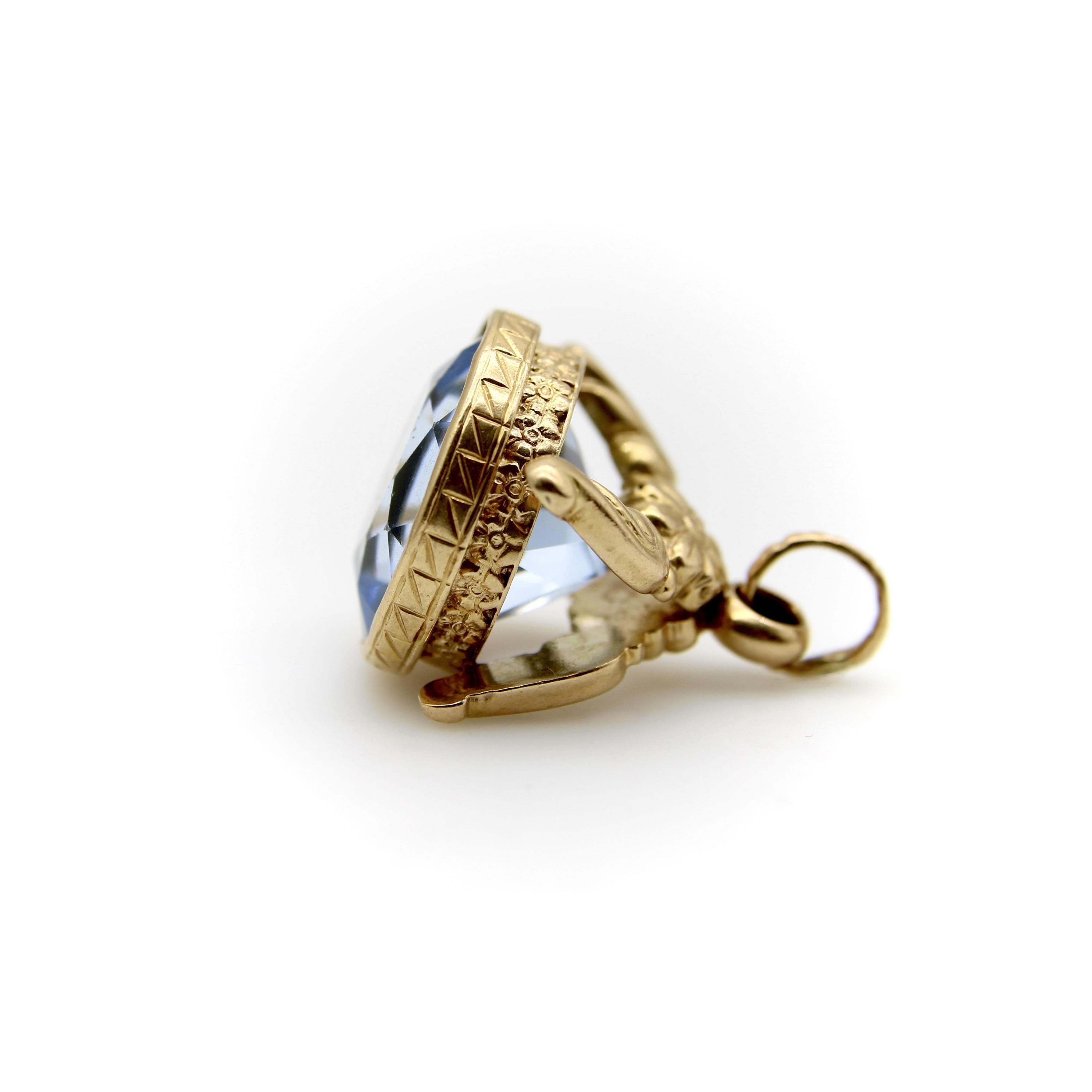 Questo bracciale vintage in oro 14k è caratterizzato da una splendida pietra in pasta blu saturo sfaccettata. La parte superiore del portachiavi è costituita da un fiore centrale che si trasforma in due elementi a forma di foglia. Alla base, un