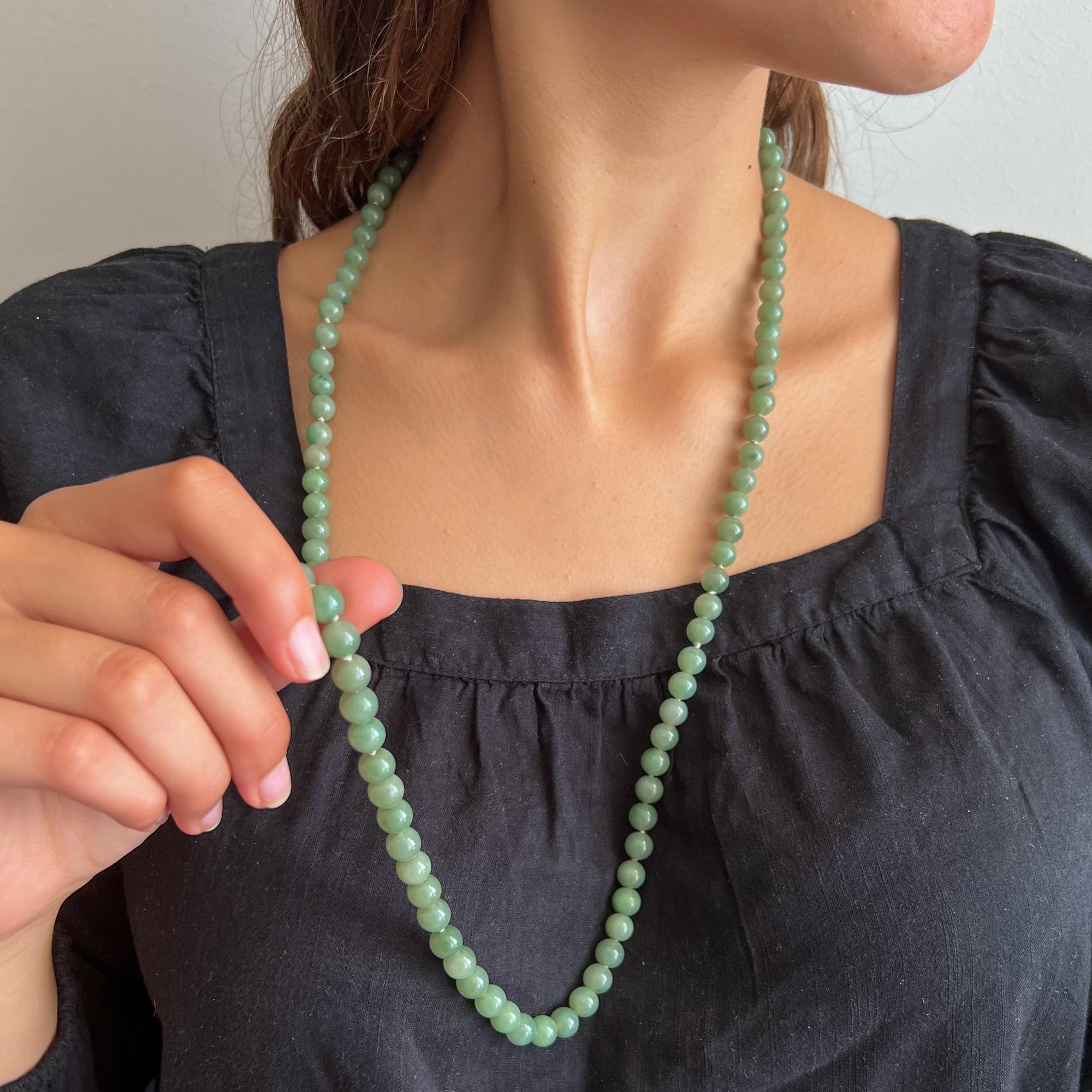 A vintage green jade single-strand beaded necklace with a 14 karat clasp in the shape of a barrel. The necklace consists of beautiful round-shaped jadeite jade stones, the jade beads have a very nice green color. The strands are strung with round