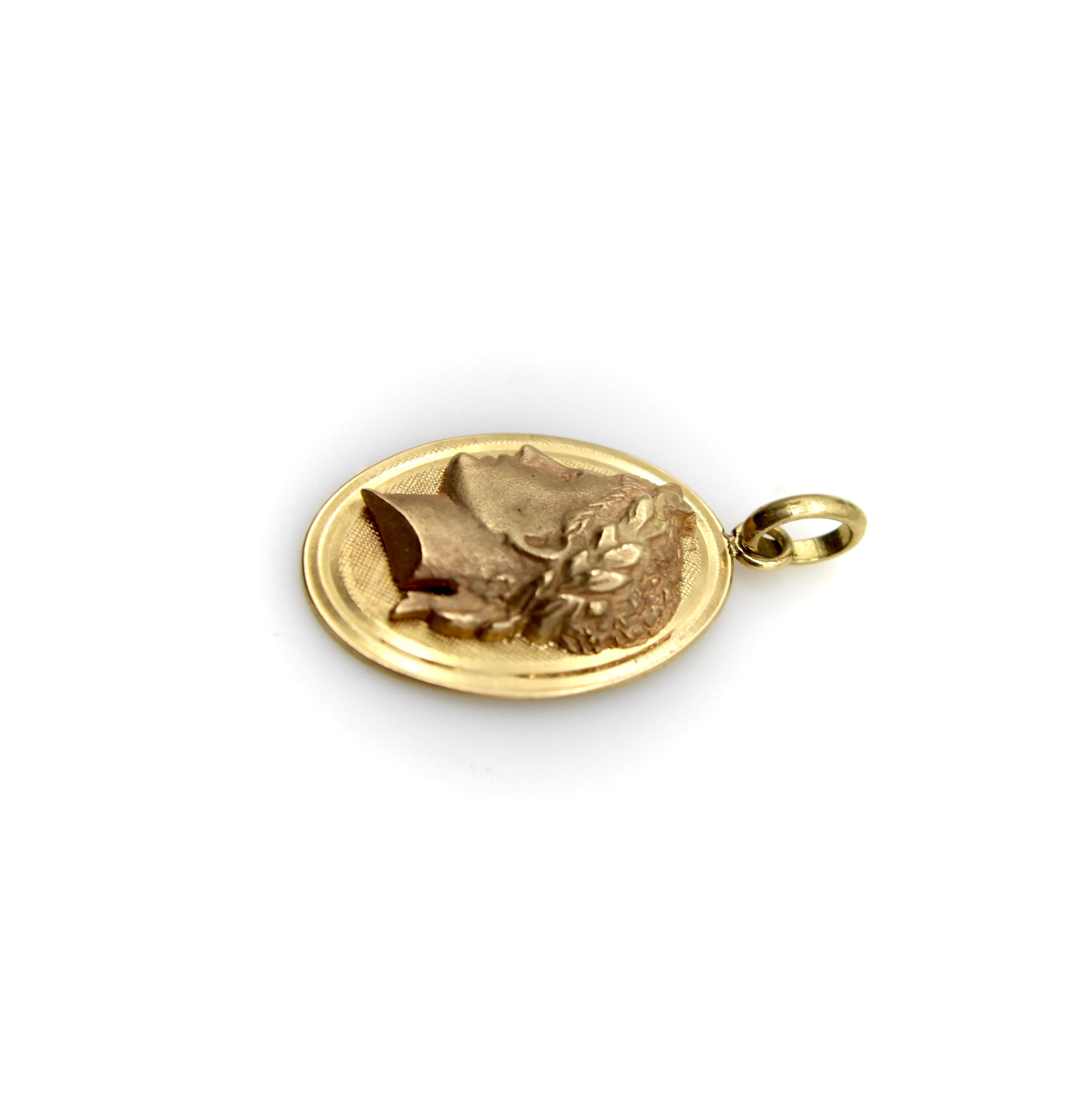 Ein nach links gewandtes Porträt von Julius Caesar in schönem, mattem 14-karätigem Gold. Caesar trägt die Siegeskrone, und das Profil befindet sich auf einem ovalen Medaillon mit schraffiertem Hintergrund. Der Charme hängt an einem ovalen Bügel und