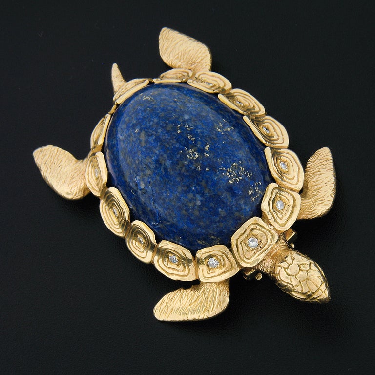 Here we have a magnificent vintage brooch that was well-crafted from solid 14k yellow gold. This outstanding piece features a very detailed turtle design with a large natural lapis stone set as its shell, in which is further surrounded by 14 single