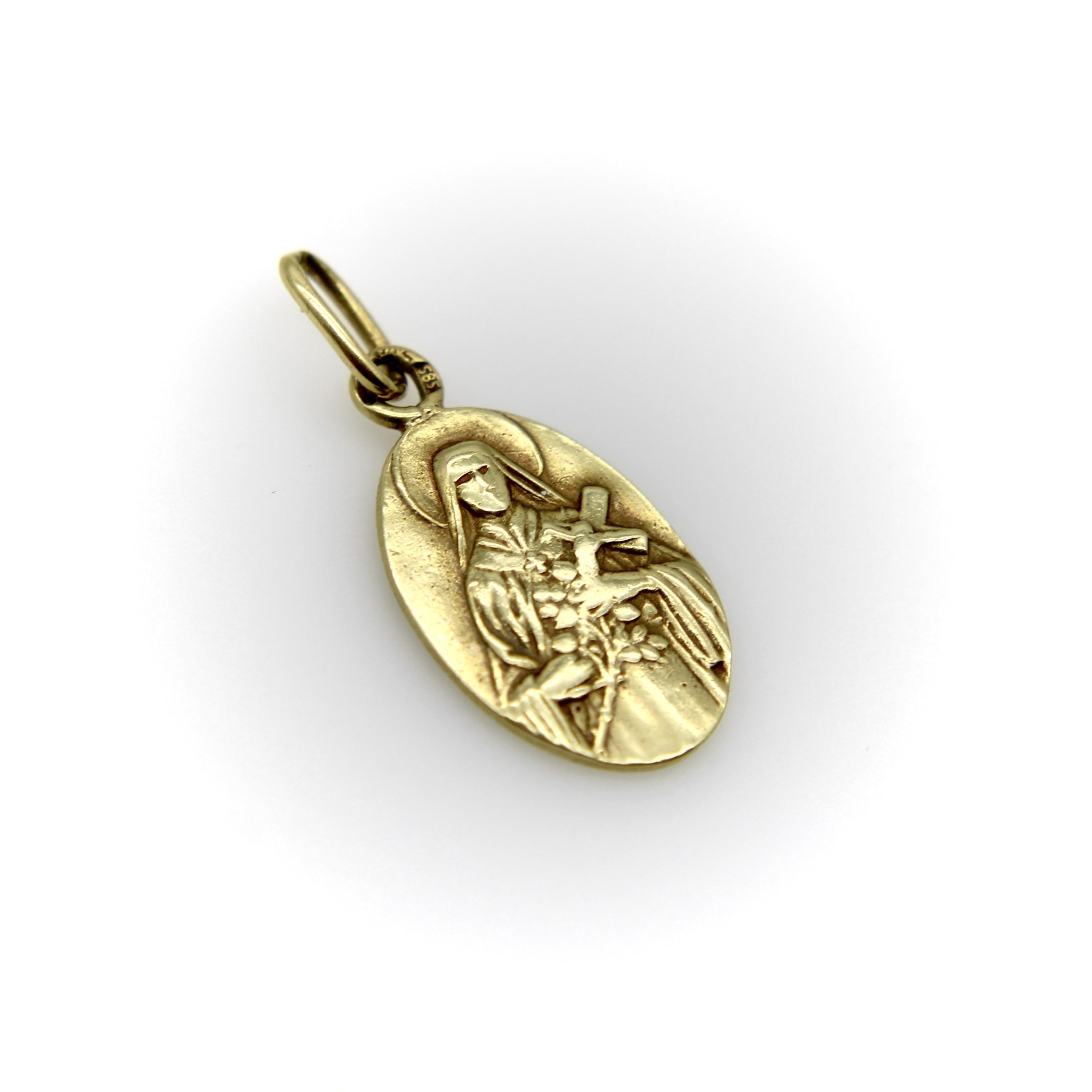 Trouvé lors d'un récent voyage à Prague, ce pendentif en or 14k date des années 1930 ou 1940. Il s'agit d'un portrait de Sainte Marie tenant une croix et des fleurs, avec une auréole rayonnant au-dessus de sa tête. Les détails de l'image sont encore