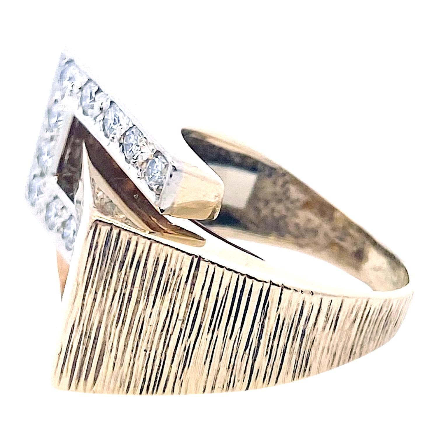 Constructed from a harmonious blend of 14k yellow and white gold, this mid-century ring features a unique angular motif that captures attention with its modern aesthetic. The piece is adorned with brilliant-cut white diamonds, and has a bright