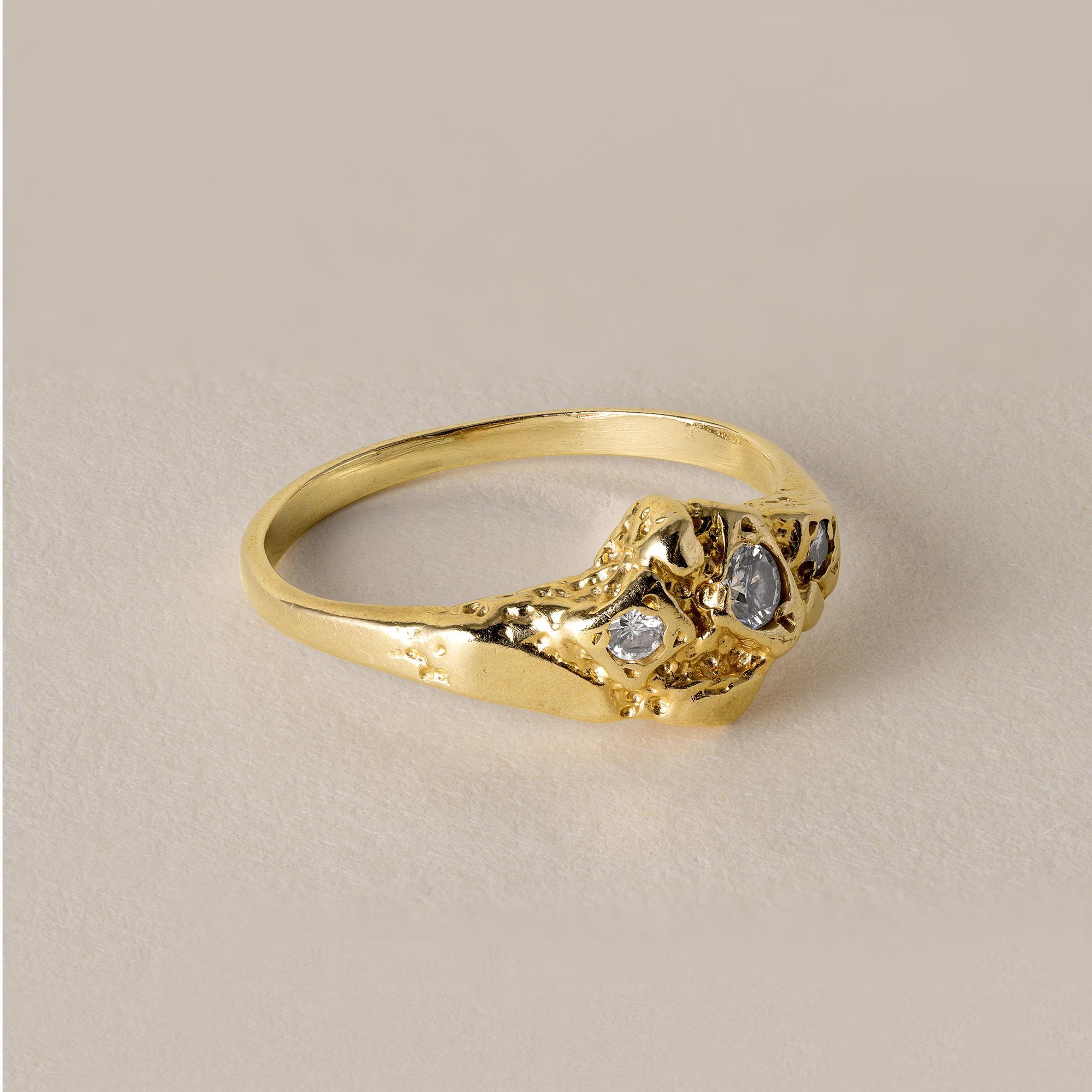 Circa 1970s
Three round brilliant diamonds weigh 0.06 carats
1.8 grams
gold nugget pattern throughout
Rings size 4.25
14K stamped in shank