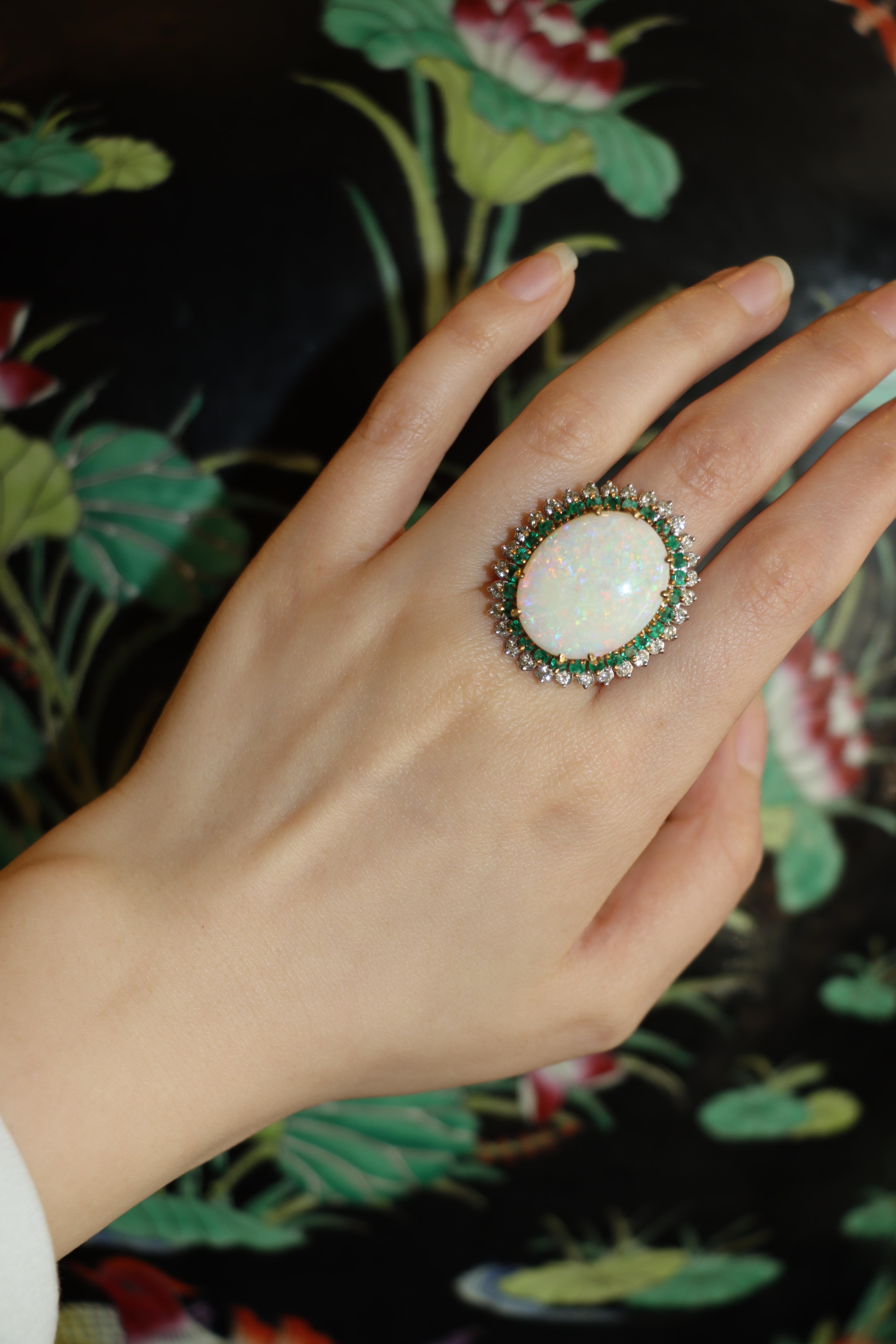 A Vintage 14K White & Yellow Gold Opal Emerald Diamond Cocktail Ring. 

Approximate Dimensions: 
6.5 (Ring Size) 
22.47 x 18.16 mm (center opal) 
Approx. 2.1 Carats (Diamond) 
Approx. 1.4 Carats Total (Emeralds) 
16.1 grams in weight.

** All
