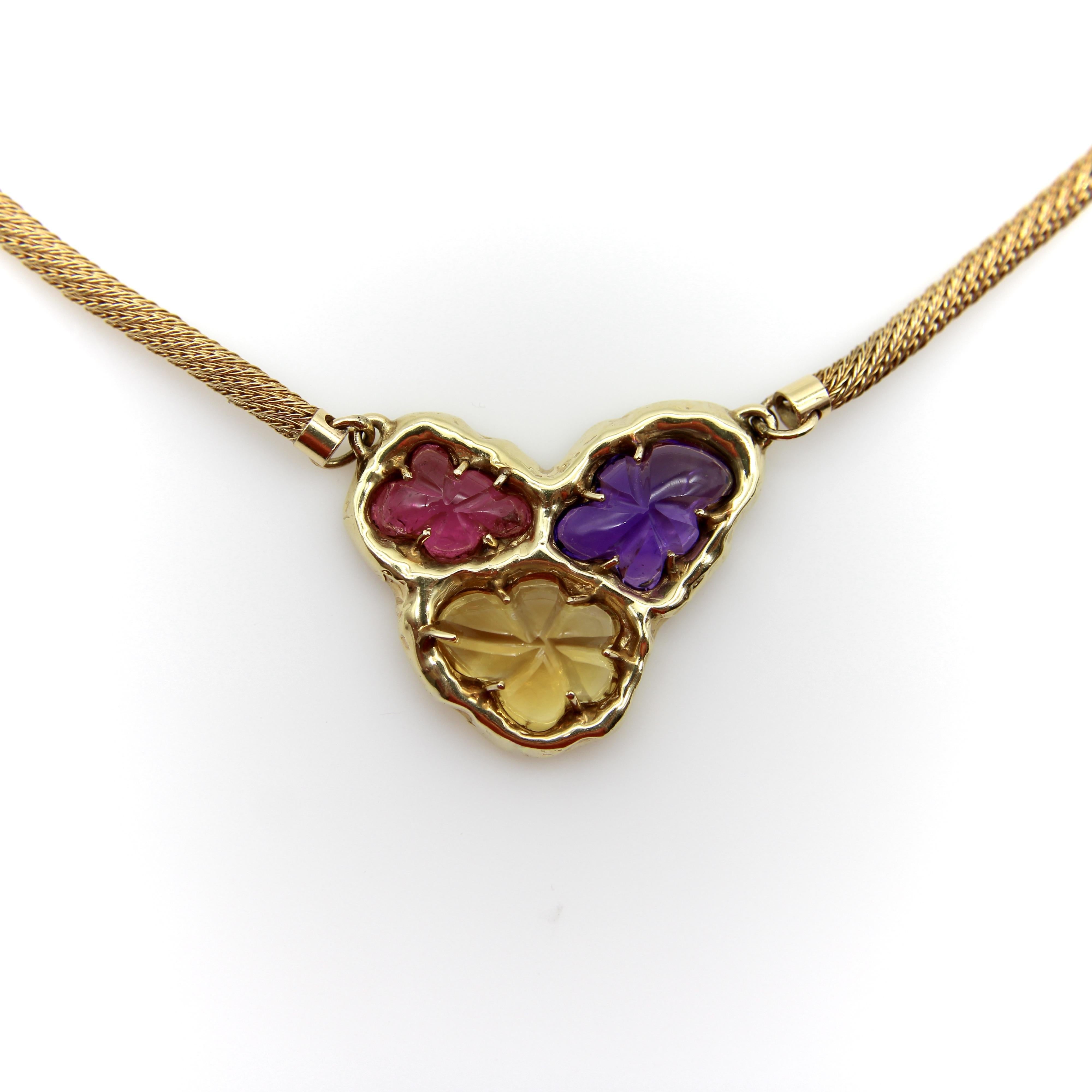 Circa the 1970’s or 1980’s, this 14k gold gemstone necklace is bold and unique. Three amoebic floral shaped gemstones come together in a form reminiscent of a cellular organism. The organic setting holds the stones in place with prongs and the
