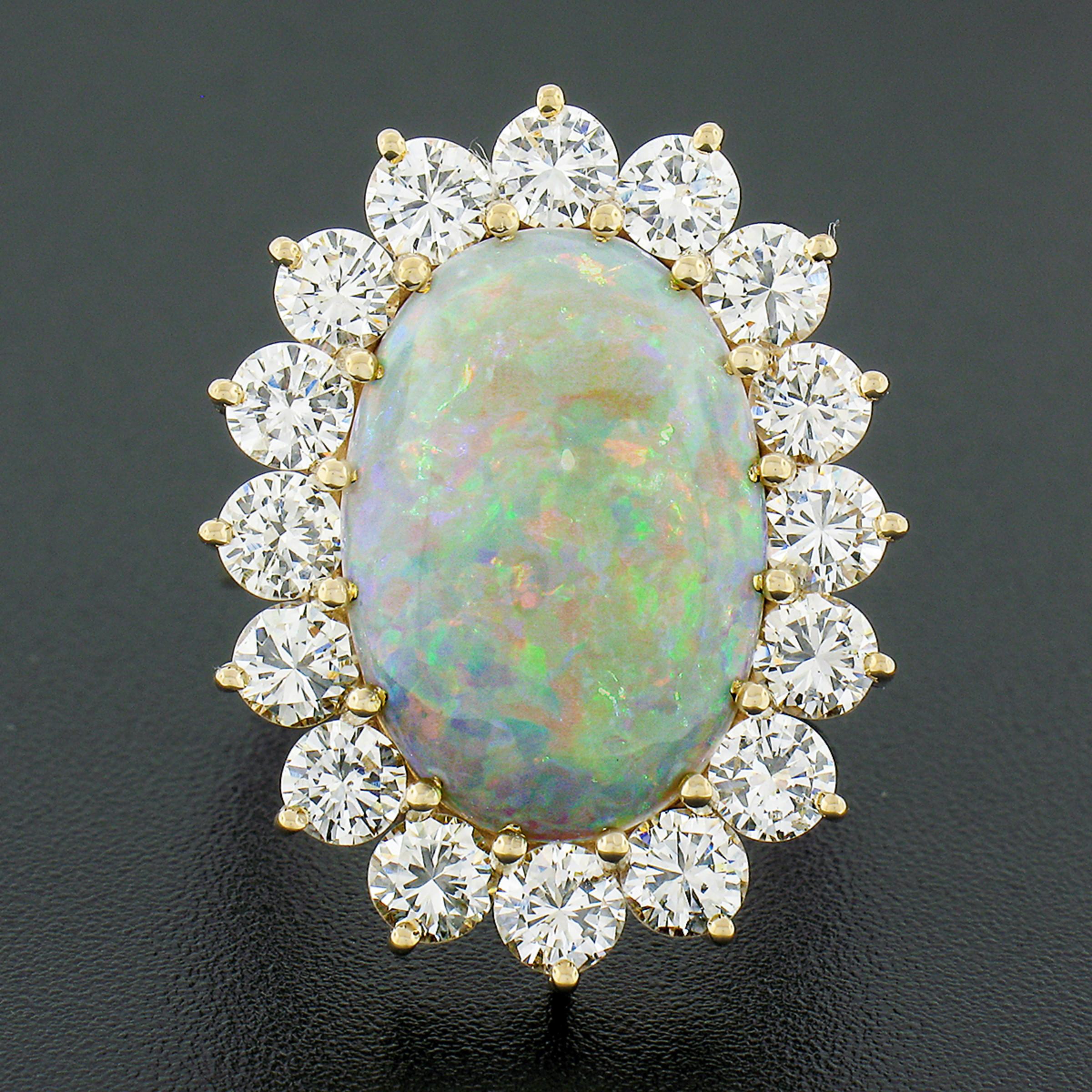 This magnificent fancy vintage ring is crafted in solid 14k yellow gold and features a breathtaking opal gemstone neatly and elegantly multi-prong set at the center of stunning halo design. The white opal is in excellent condition, has NO CRAZING,