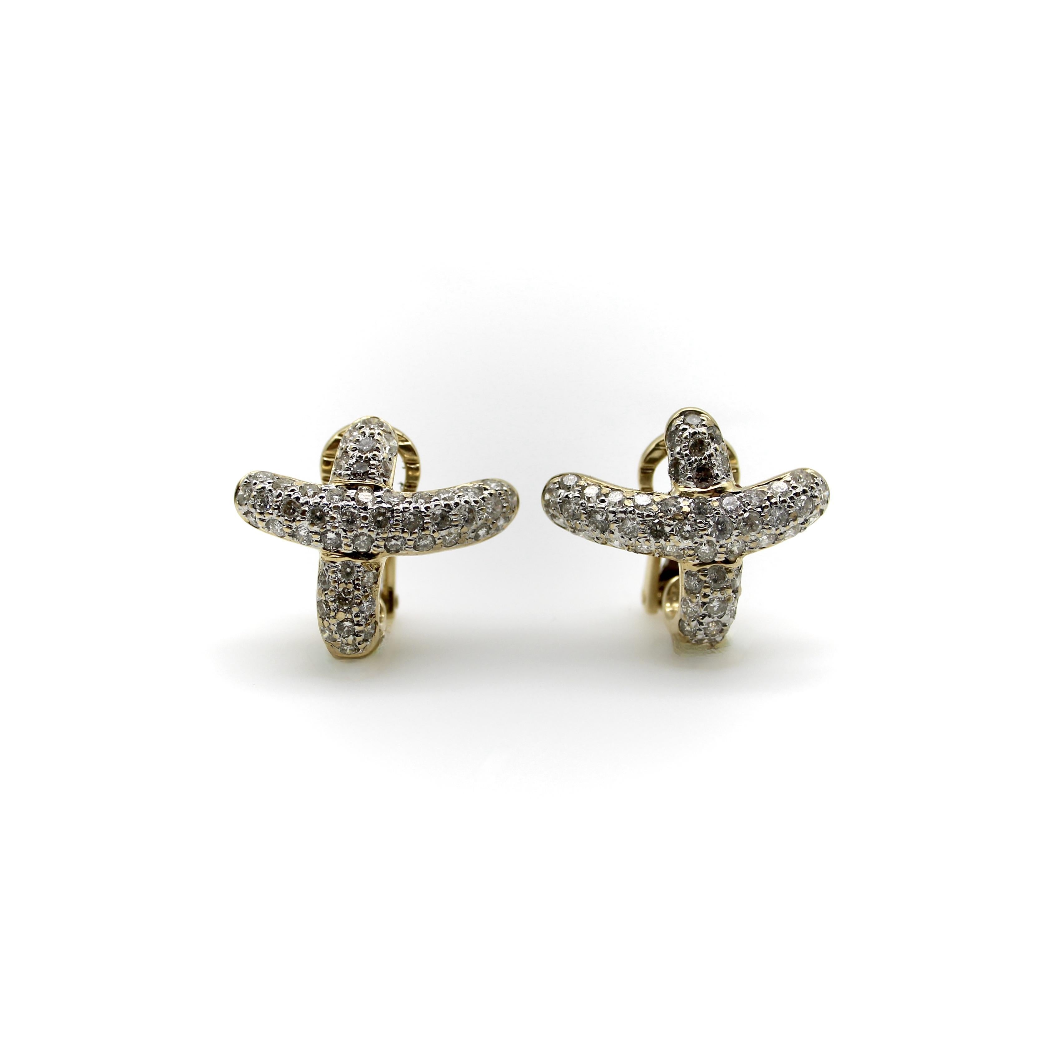 These 14k gold diamond earrings have a calligraphic X as a motif. The curve of the earring swoops up, and can be placed to follow the shape of the ear. The earrings contain bead set pave diamonds set in a pattern that completely covers the surface