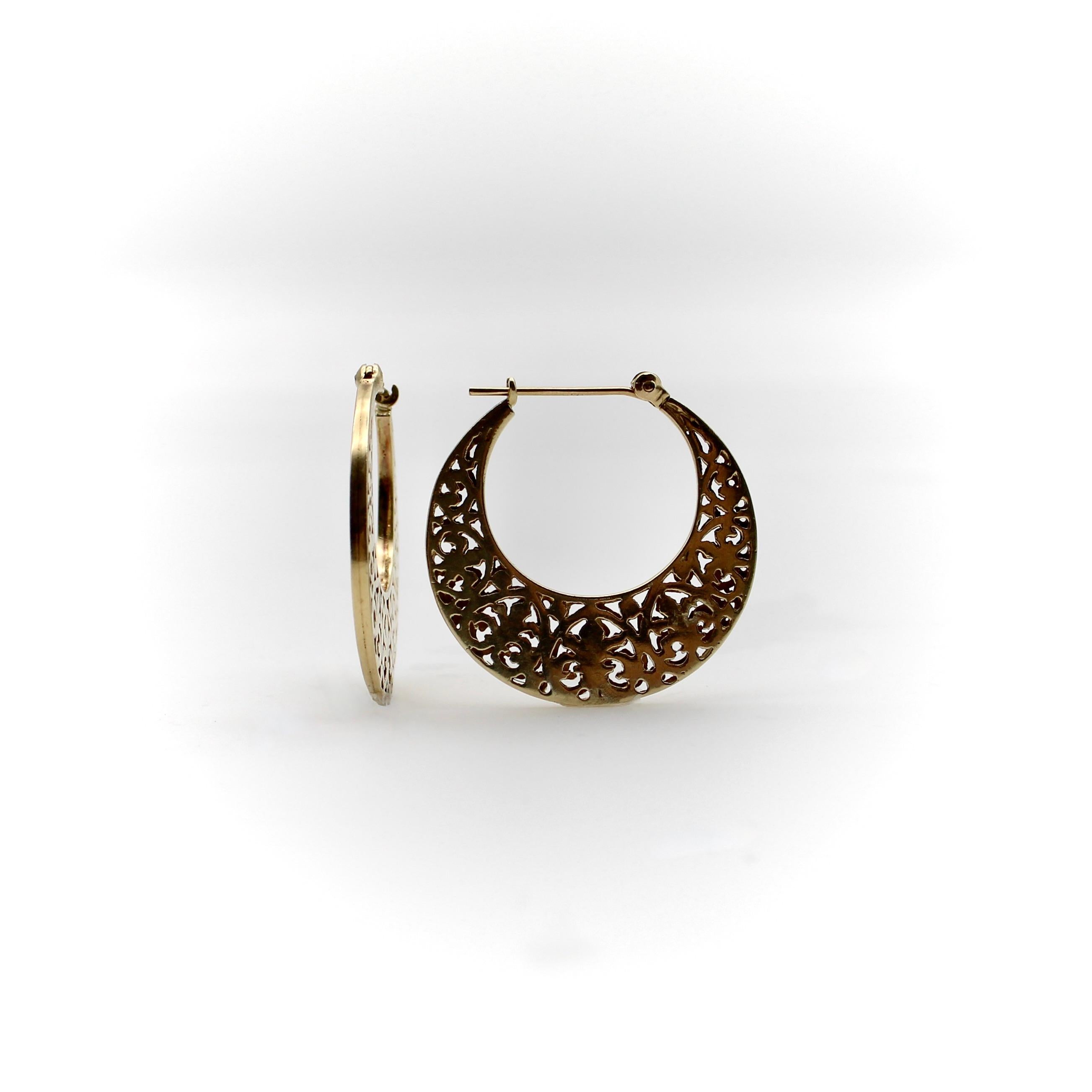 A very special pair of 14k gold vintage hoops that, when viewed from the side, are shaped like crescent moons. The earrings have a reticulated pattern that’s based on a fleur-de-lys motif. They consist of two layers of gold sandwiched on top of each