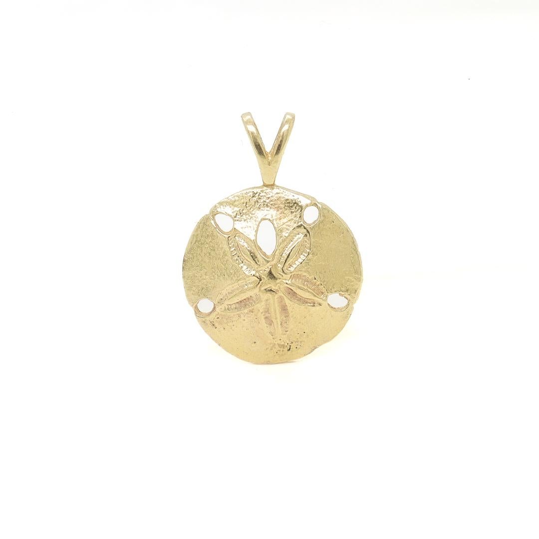 A fine sea shell charm for a bracelet.

In 14k gold.

In the form of a miniature sand dollar.

With an integral bail to the top.

Simply a wonderful gold charm!

Date:
Mid-20th Century

Overall Condition:
It is in overall good, as-pictured, used