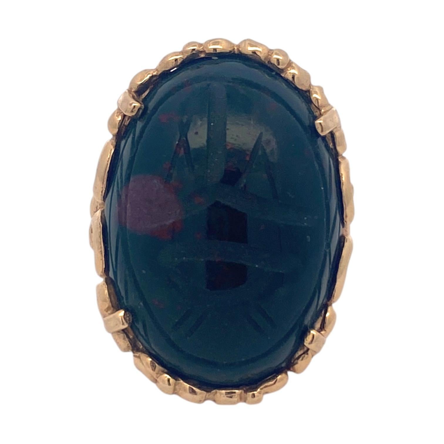 Fabriquée en or jaune 14k, cette bague est ornée d'une pierre de sang taillée en cabochon et d'un motif de scarabée. La conception néo-égyptienne est évidente dans les détails complexes en or qui entourent la pierre.
Mesures :
Longueur : 27,5