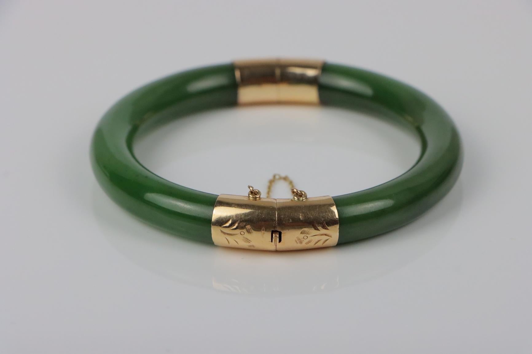 Vintage 14K Gold & Spinach Jade Bangle 
Solid 14K Gold mounted on Spinach Jade Bangle
Illegibly stamped on clasp insert.

Approximate Dimensions:
17.8 cm (Inner Wrist Diameter) x 8.80 mm (Thickness) 
41.7 grams in weight