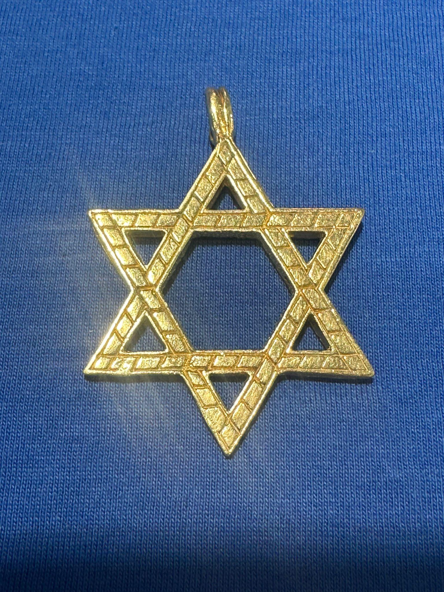 This exquisite vintage Star of David pendant is a remarkable piece of Judaica, handcrafted in Israel in the 1970s from solid 14K gold. Weighing approximately 15 grams, this pendant boasts a bold yet elegant presence, making it a meaningful and