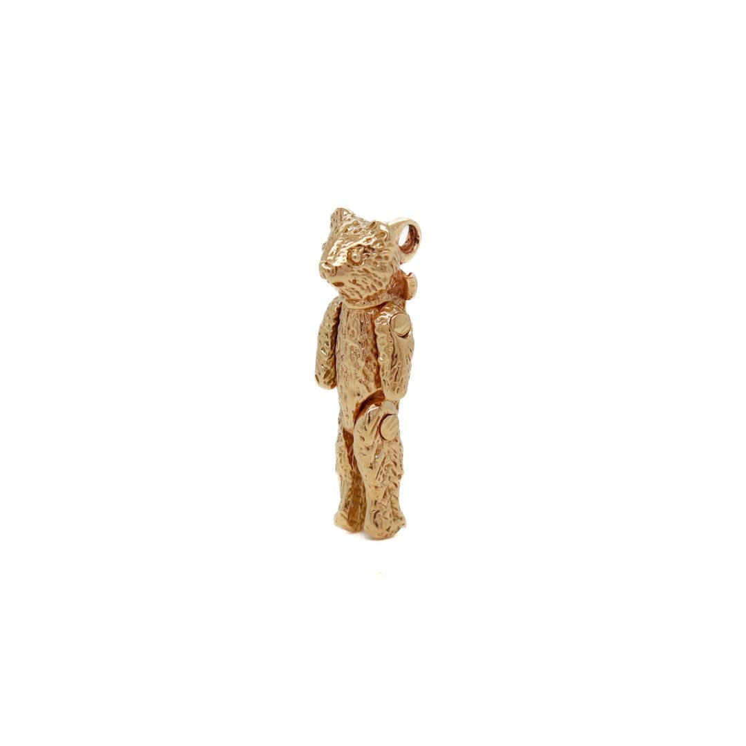 A fine vintage charm for a bracelet.

In 14k yellow gold. 

In the form of a teddy bear with a bow around its neck.

With moving arms and legs.

Fixed with a bail to the reverse of its head.

Simply a wonderful teddy bear charm!

Date:
20th