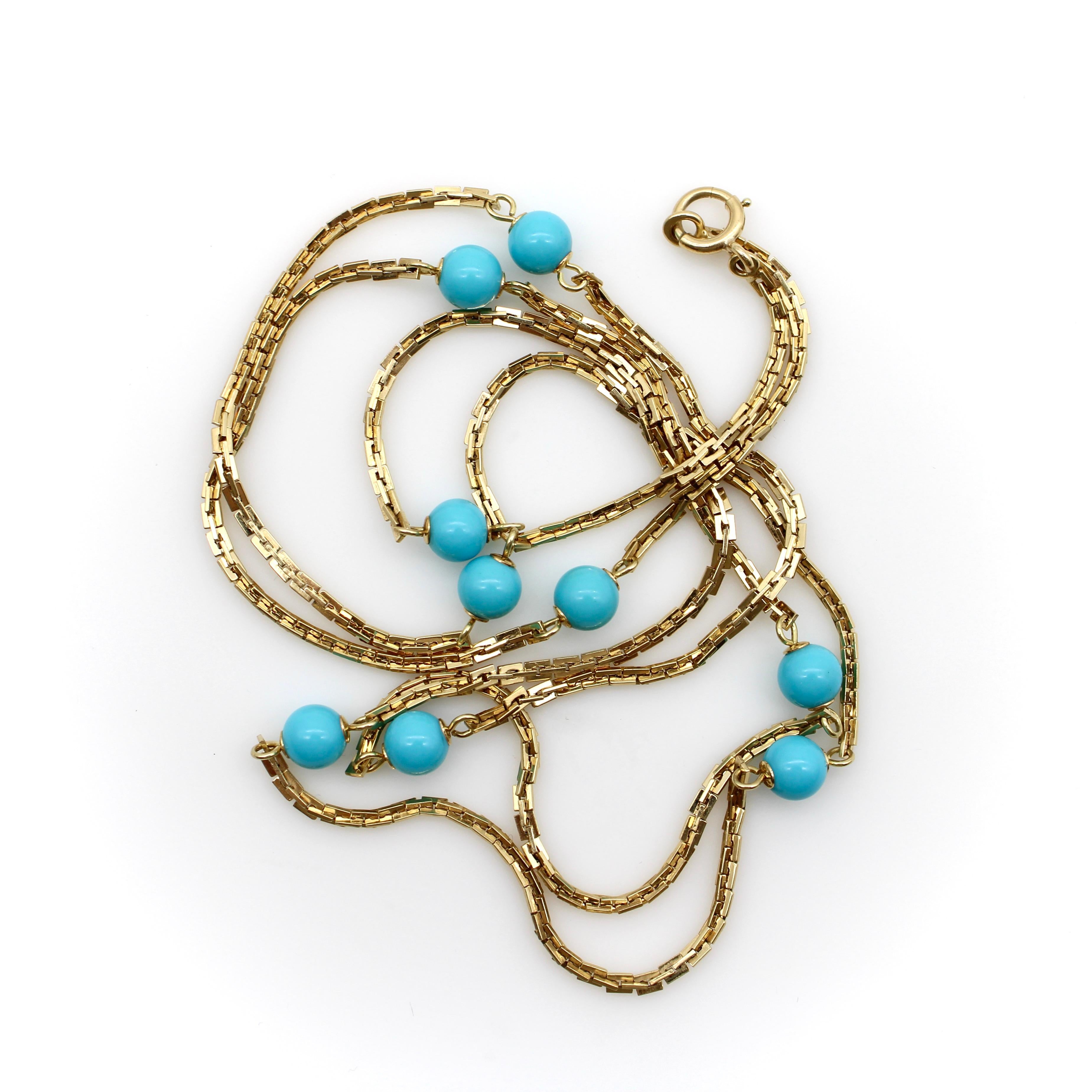 This extra long 14k gold necklace has stations of nine round turquoise beads. The chain consists of a rectangular link that bisects itself to create a rhythmic pattern. The link has lots of dimensionality to it that adds a shimmer as the light
