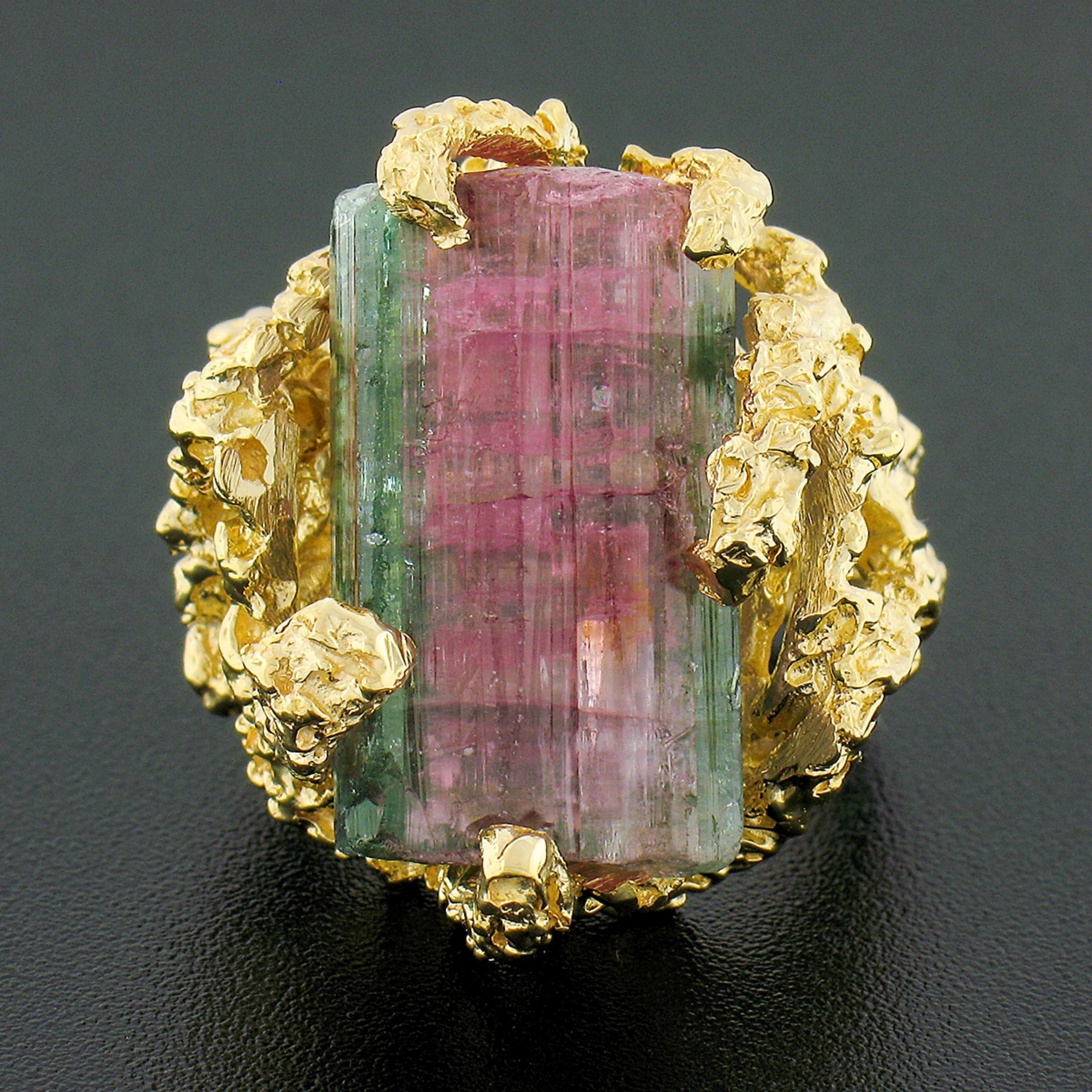 This unique vintage statement ring is crafted in solid 14k yellow gold and is set with a gorgeous, rough, uncut watermelon tourmaline stone at its center. The stone is a large size, weighing approximately 25 carats, with gorgeous green and purplish