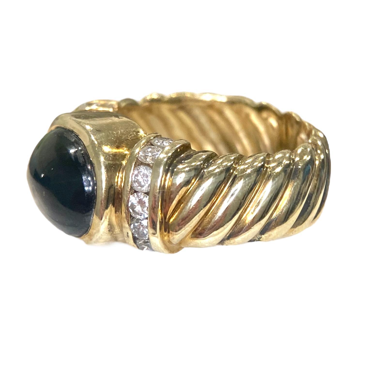 Anello vintage in oro giallo 14 carati con al centro una straordinaria tormalina verde tagliata a cabochon. Affiancato da file di diamanti bianchi taglio brillante, su una fascia larga e ritorta in stile cavo.
Tormalina: 4.5 ct.
Diamanti: 0,60 ctw.