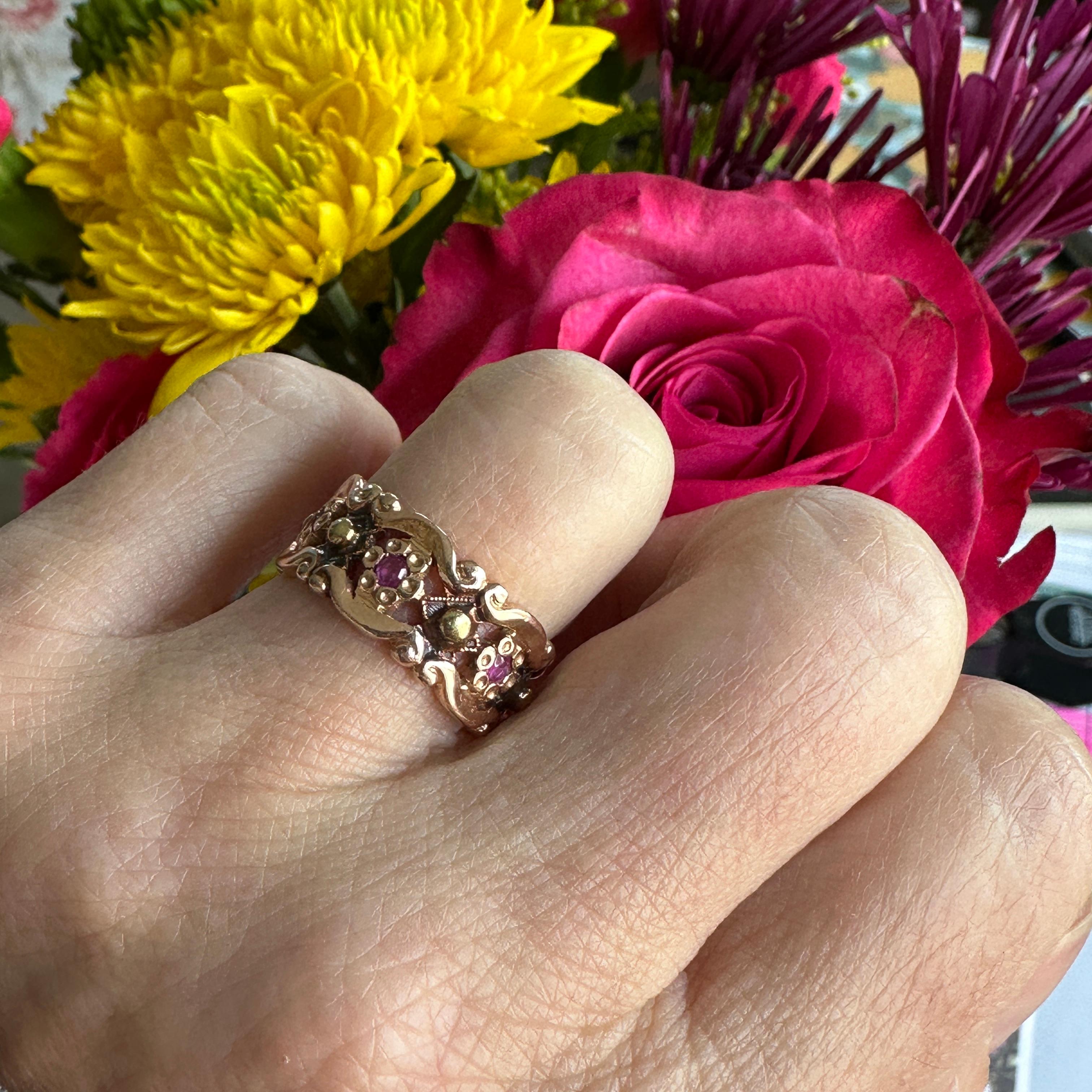 Détails :
Très douce alliance vintage à motif floral en or rose 14 carats, fleur ornée de rubis avec de petits accents d'or jaune. De douces fleurs au centre rubis et de petits motifs en forme de boules et de fleurs ornent l'ensemble de la bande. Ce