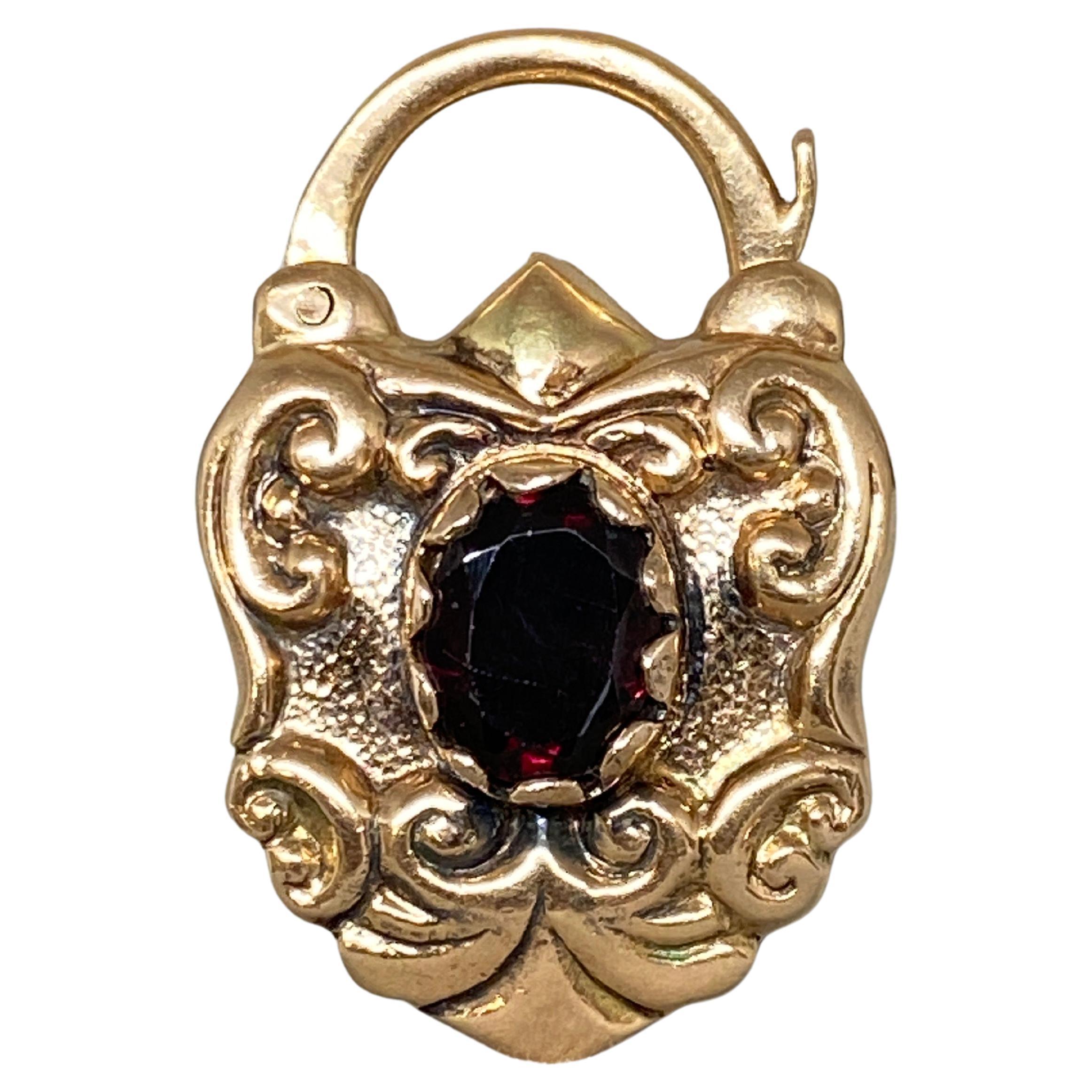 Up for your consideration is this delightful large gem set padlock charm pendant superbly made in 14k rosey-yellow  gold.

From the mid-twentieth century, this padlock charm is ornately decorated with beautiful repousse scrollwork surrounding a