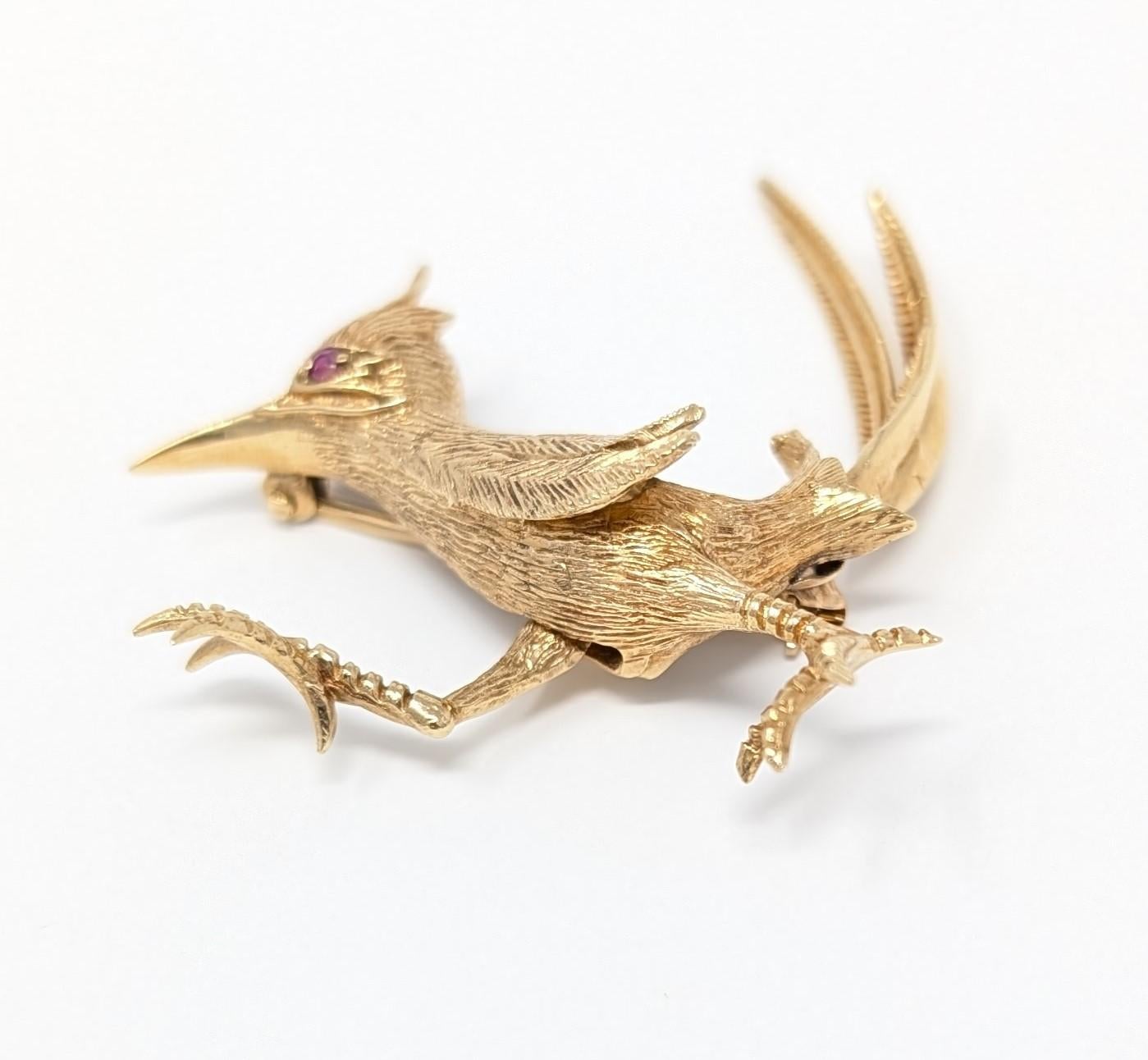 Splendid vintage roadrunner brooch created in solid 14k yellow gold, featuring a dazzling ruby eye. This wonderful little roadrunner is a kinetic piece of jewelry as its leg can move by the mechanism on the backside. Measures approximately 2 inches