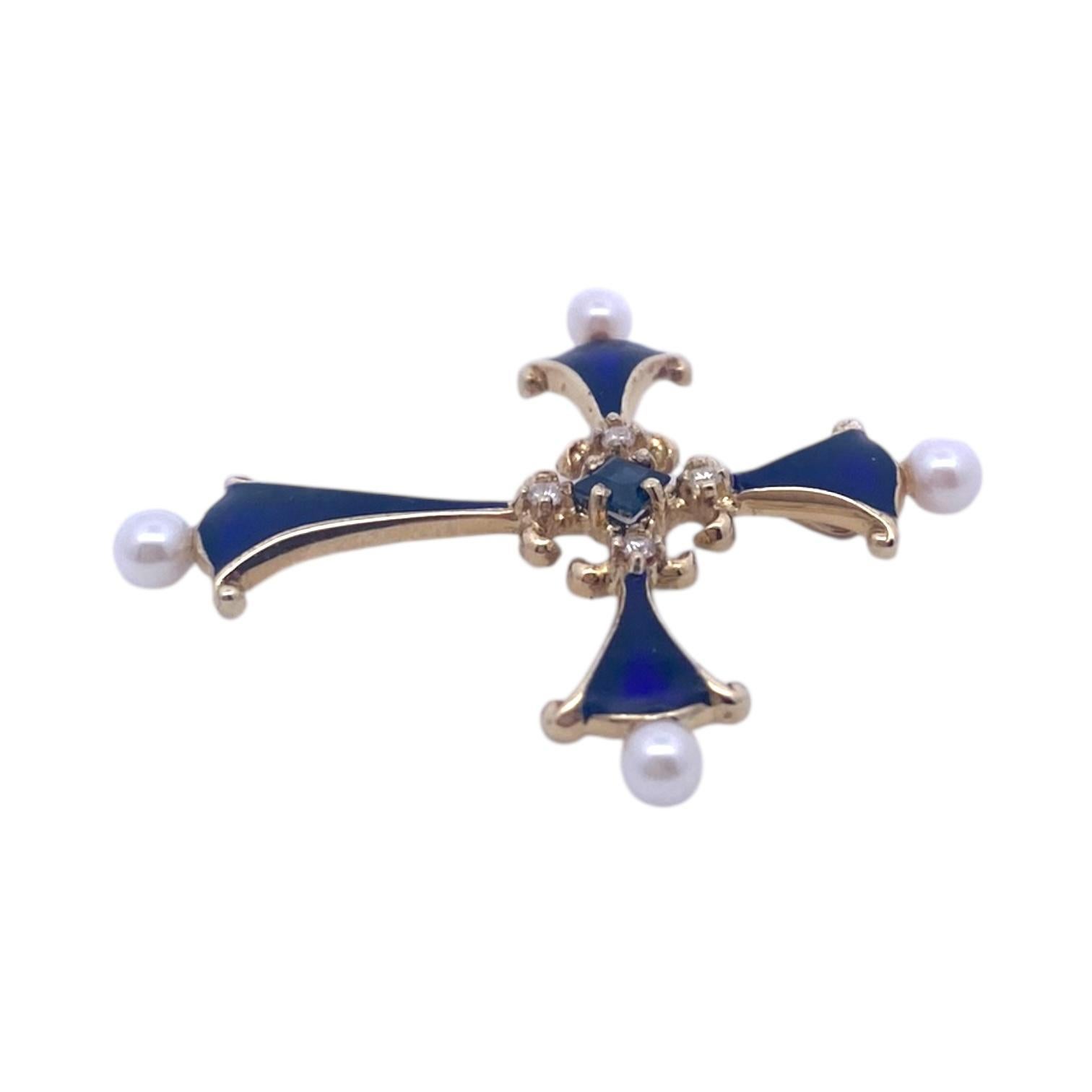 Elaborado en oro amarillo de 14 quilates, este colgante presenta un diseño en forma de cruz adornado con esmalte azul. En su centro, un zafiro azul de talla cuadrada está engastado rodeado de diamantes talla brillante. Cada brazo de la cruz está