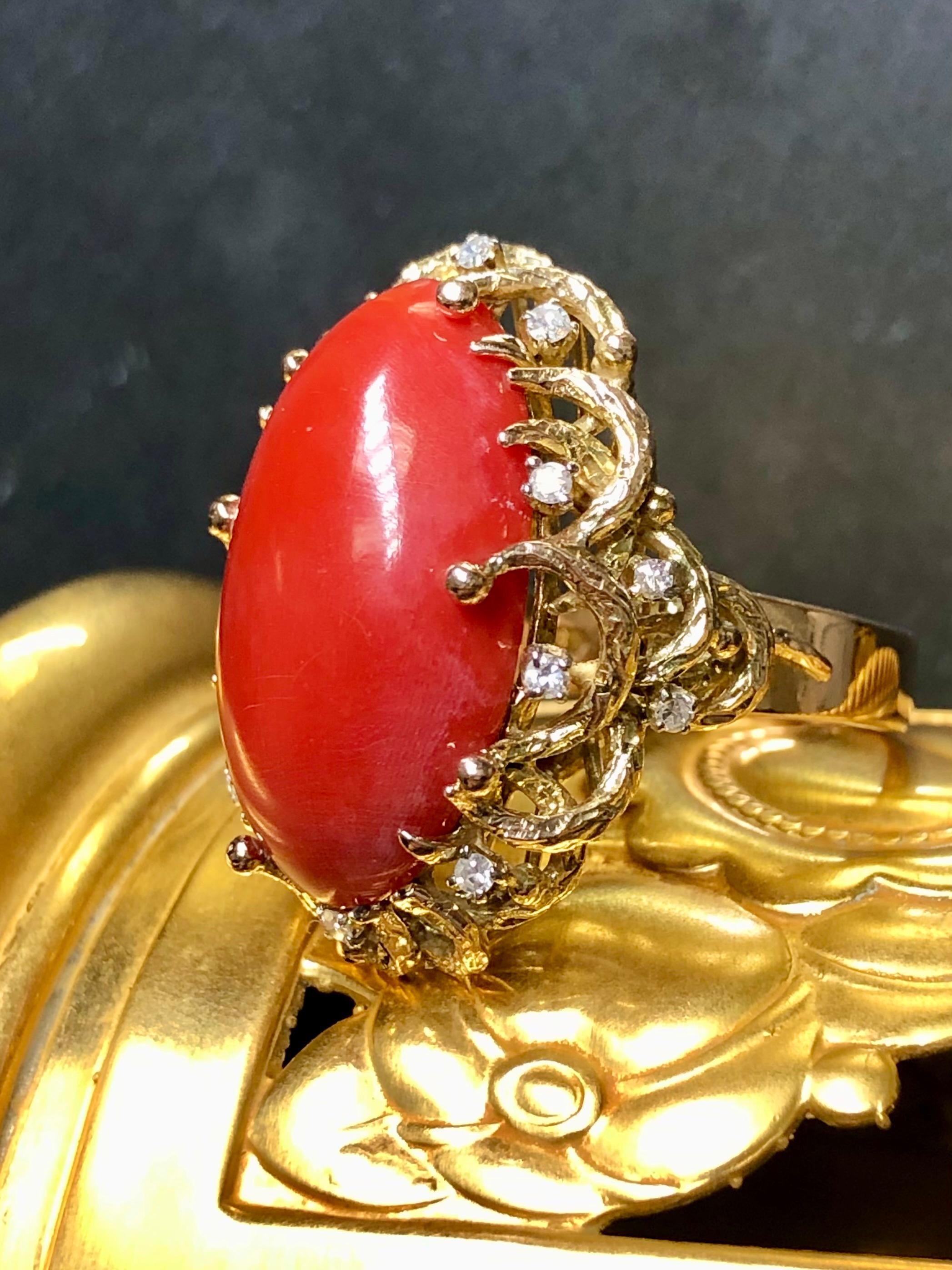 A bold, vintage cocktail ring c. the 1960’s crafted in 14K yellow gold and centered by a large cabochon cut natural coral (23.76mm x 14.25mm x 7.40mm) . The color is even and deep… and of course natural. Surrounding the coral are prongs set round