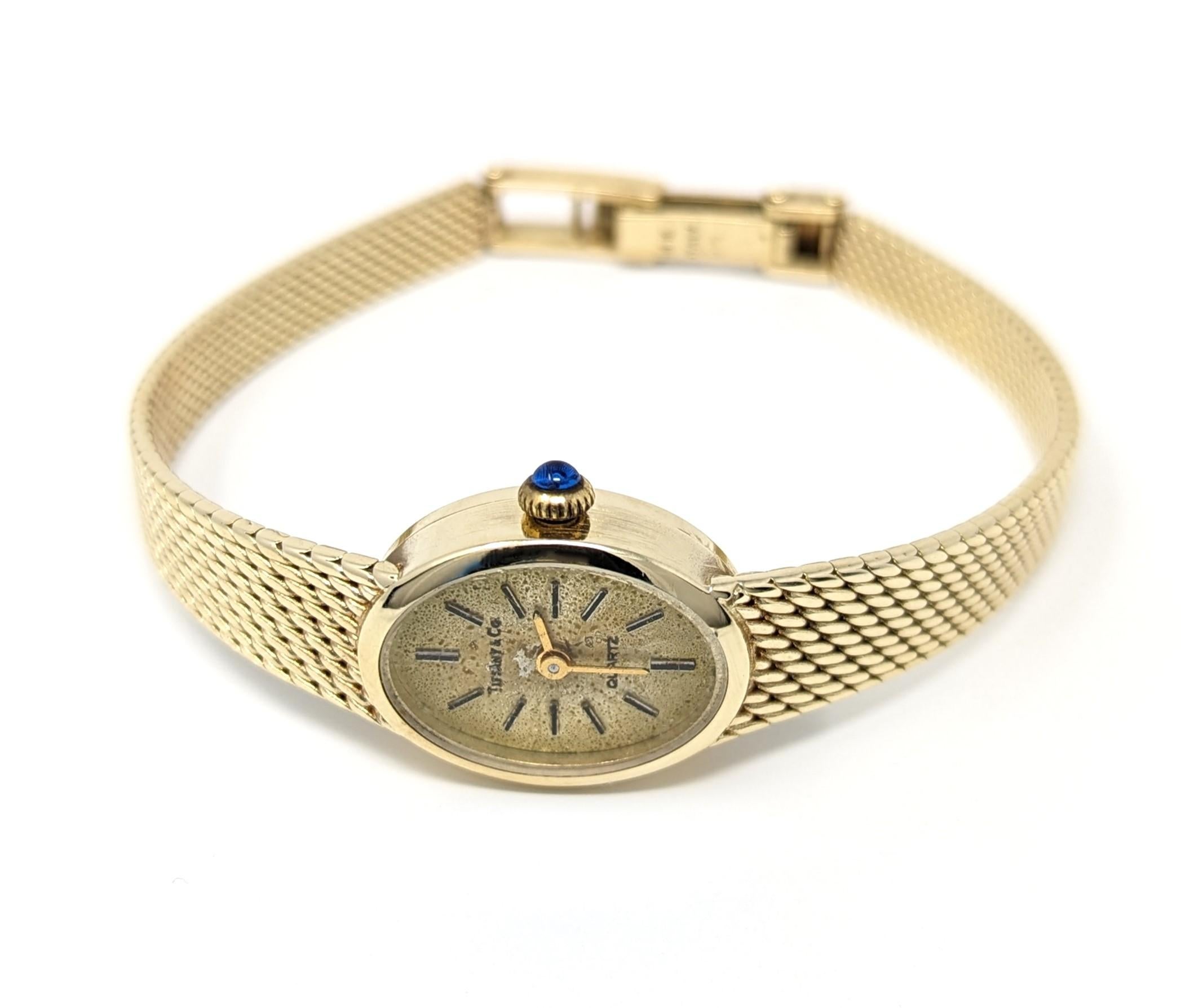Vintage 14k Tiffany & Co. ladies watch with an elegant mesh band, created in solid 14k yellow gold with a sapphire color glass crown. This wonderful watch was presented as an award for an Avon member for 25 years of service (engraved on the back).