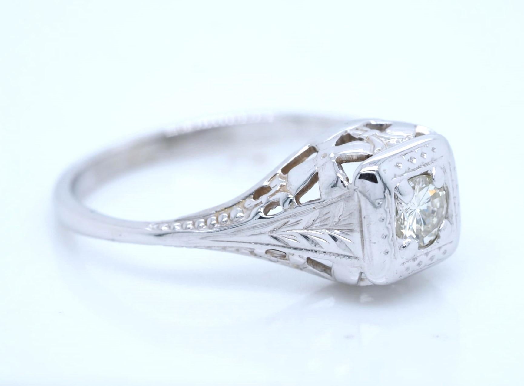 This vintage engagement ring is crafted from 14K white gold and features a stunning 0.25 ct round cut natural diamond. The prong setting style showcases the diamond's beauty, while the slightly included (SI1) clarity grade and I color grade add to