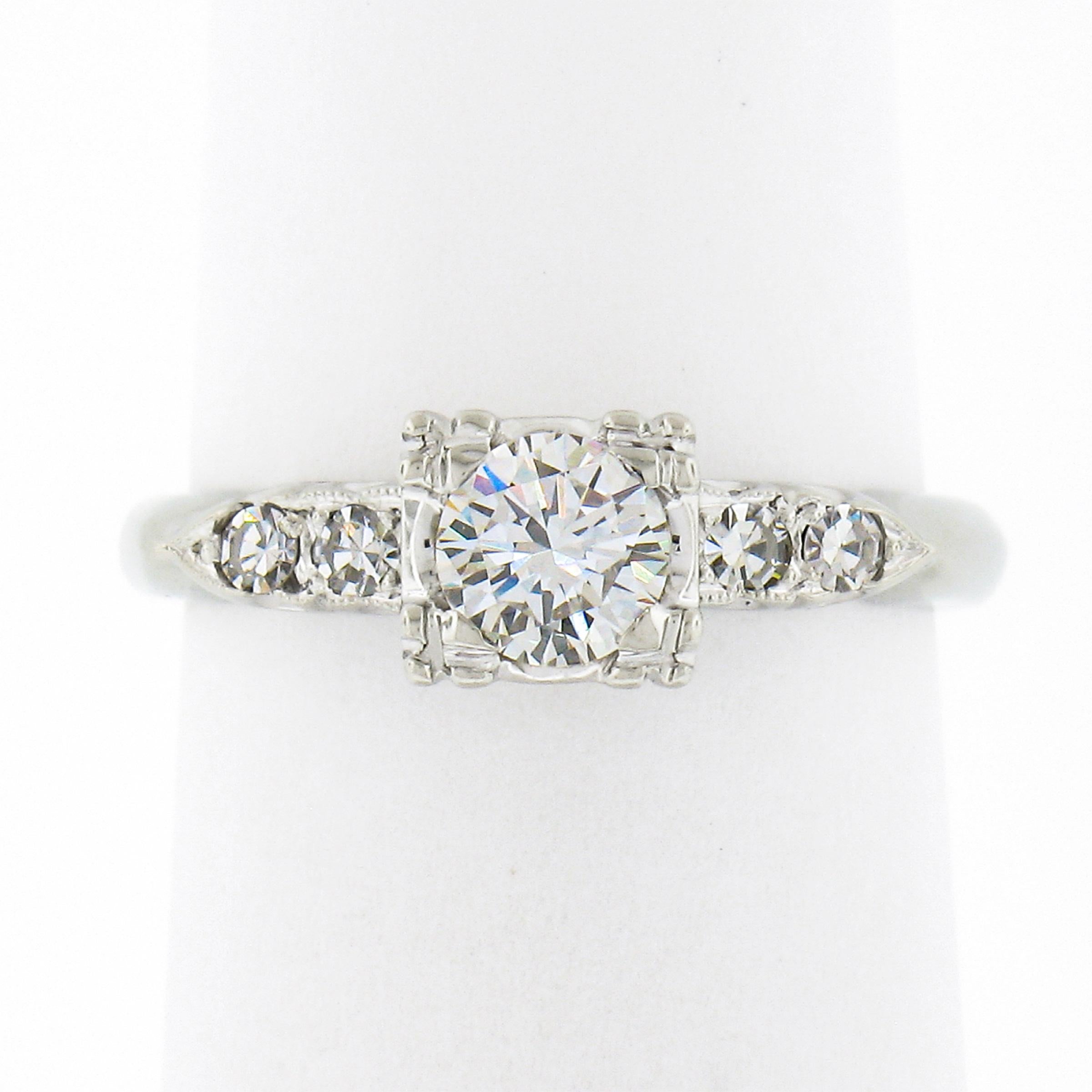 This gorgeous, all original, midcentury diamond ring was very well crafted in solid 14k white gold. It features a stunning round brilliant cut diamond neatly set at the center of the ring in a square-shaped open basket setting. The solitaire weighs