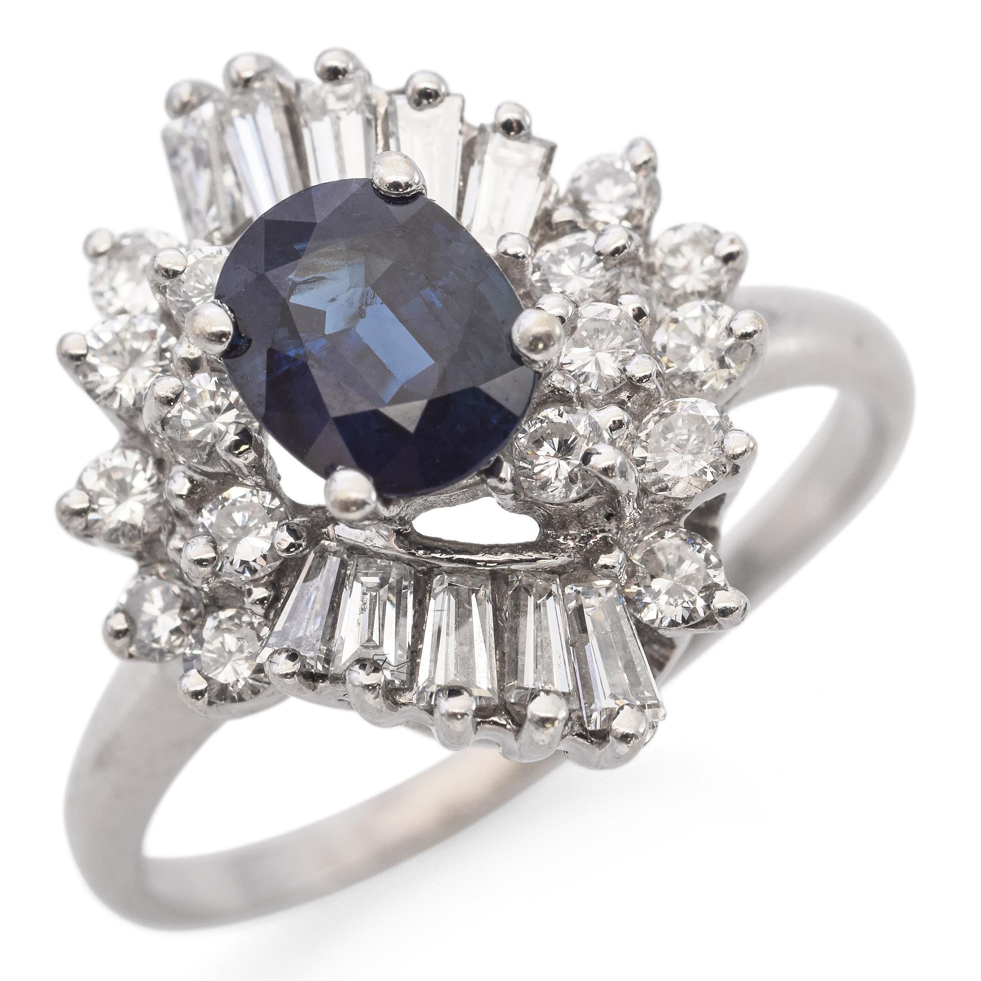 This striking ring showcases a captivating 0.86 carat oval blue sapphire at its heart. Encircling the vibrant center stone are sparkling round white diamonds adding a dazzling contrast. The stones are set in a sleek 14k white gold band, enhancing