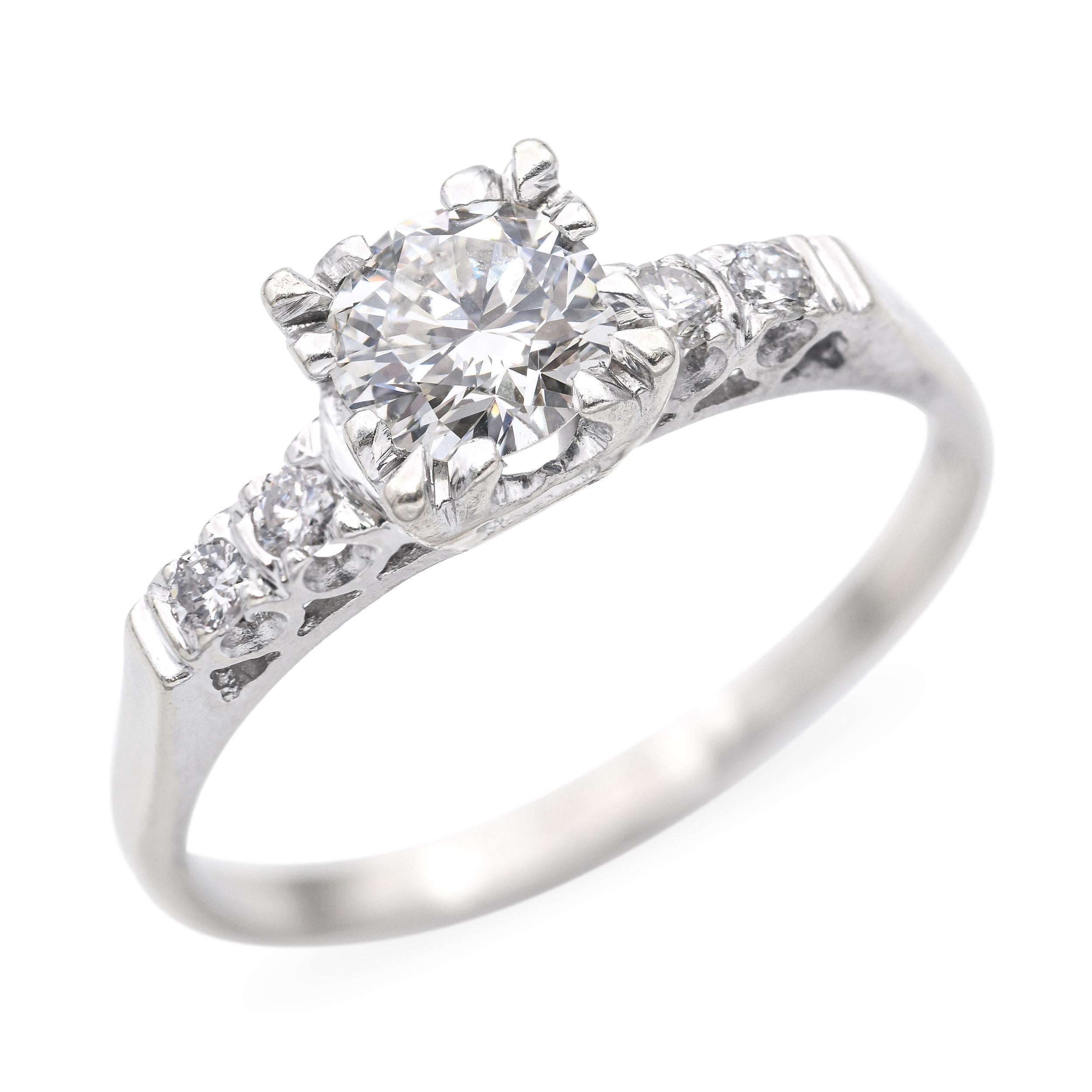 Questo elegante anello di fidanzamento vintage è caratterizzato da uno splendido peso totale di 1,12 carati di diamanti brillanti incastonati in oro bianco 14k. Il diamante centrale è classificato di colore J e purezza VS1, offrendo un bellissimo