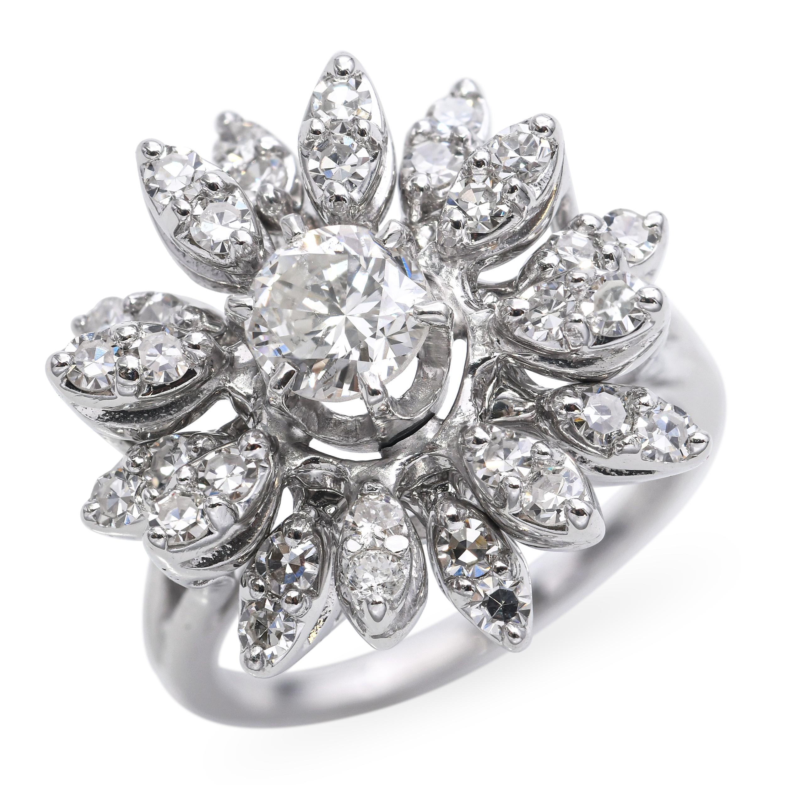 Dieser atemberaubende Vintage-Ring zeigt ein wunderschön geformtes Blumendesign, das in 14 Karat Weißgold gefasst ist und mit etwa 1,55 Karat Diamanten funkelt. Das florale Motiv wird durch die blütenblattähnlichen, übereinander liegenden Fassungen